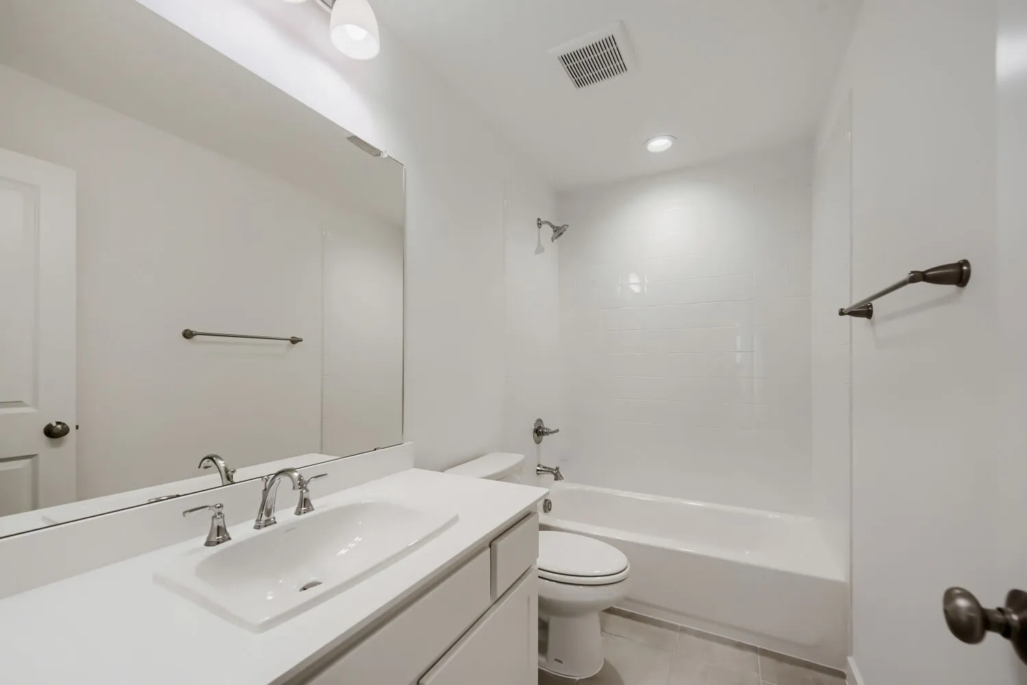 Contemporary bathroom featuring a single vanity with an integrated sink, polished chrome faucet, and expansive mirror