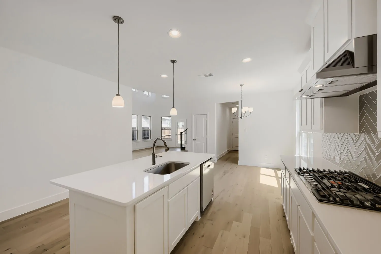 Kitchen featuring a gas range, stainless steel range hood, and herringbone tile backsplash