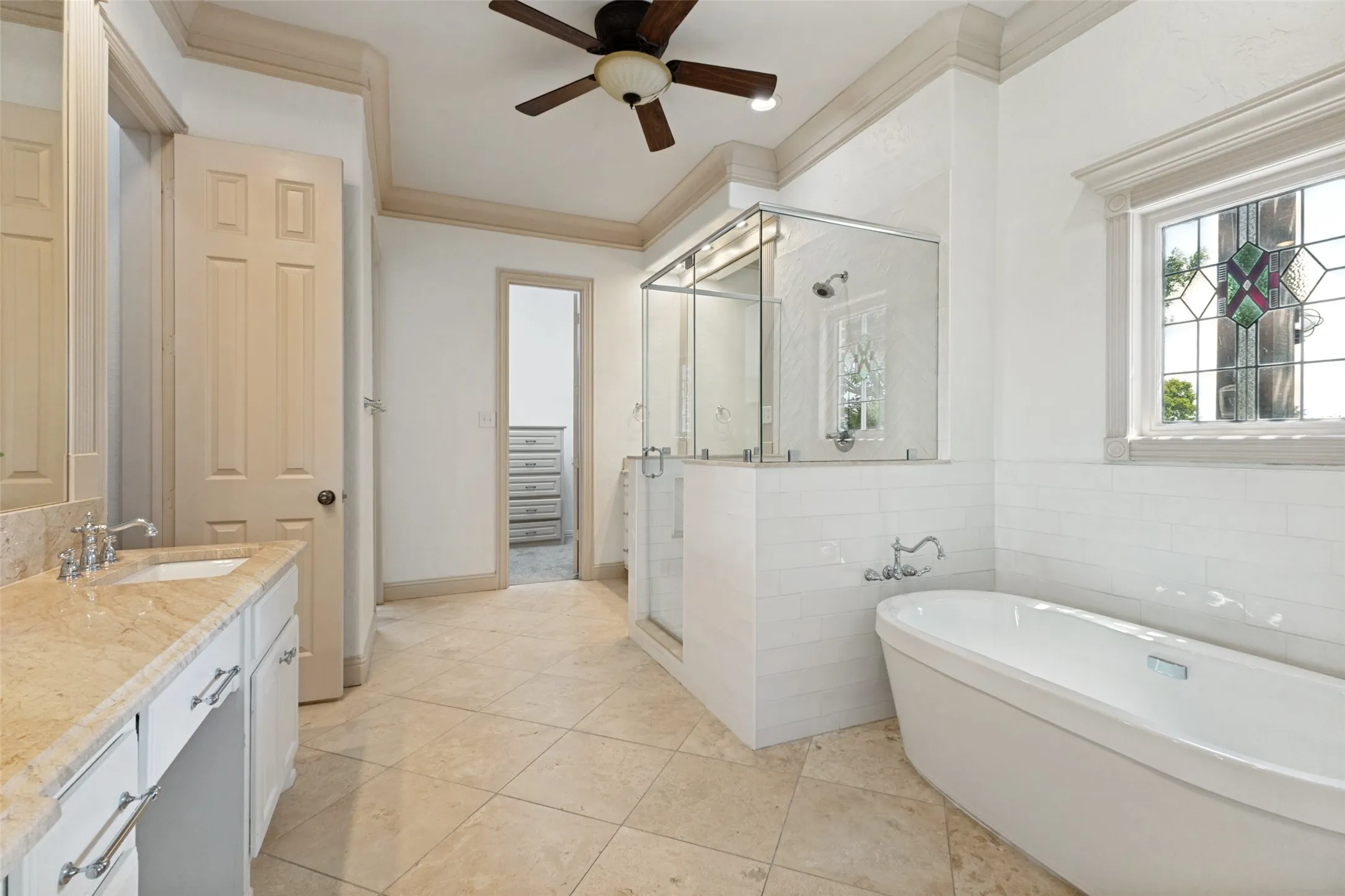 Soaking tub with intricate glass window feature.