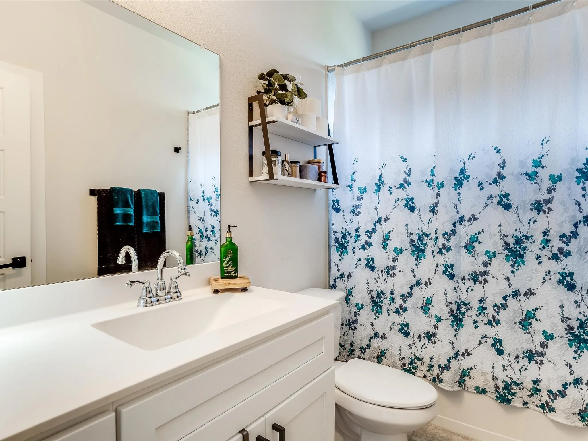 Bathroom featuring a vanity with a white countertop and integrated sink, chrome faucet, and white cabinetry