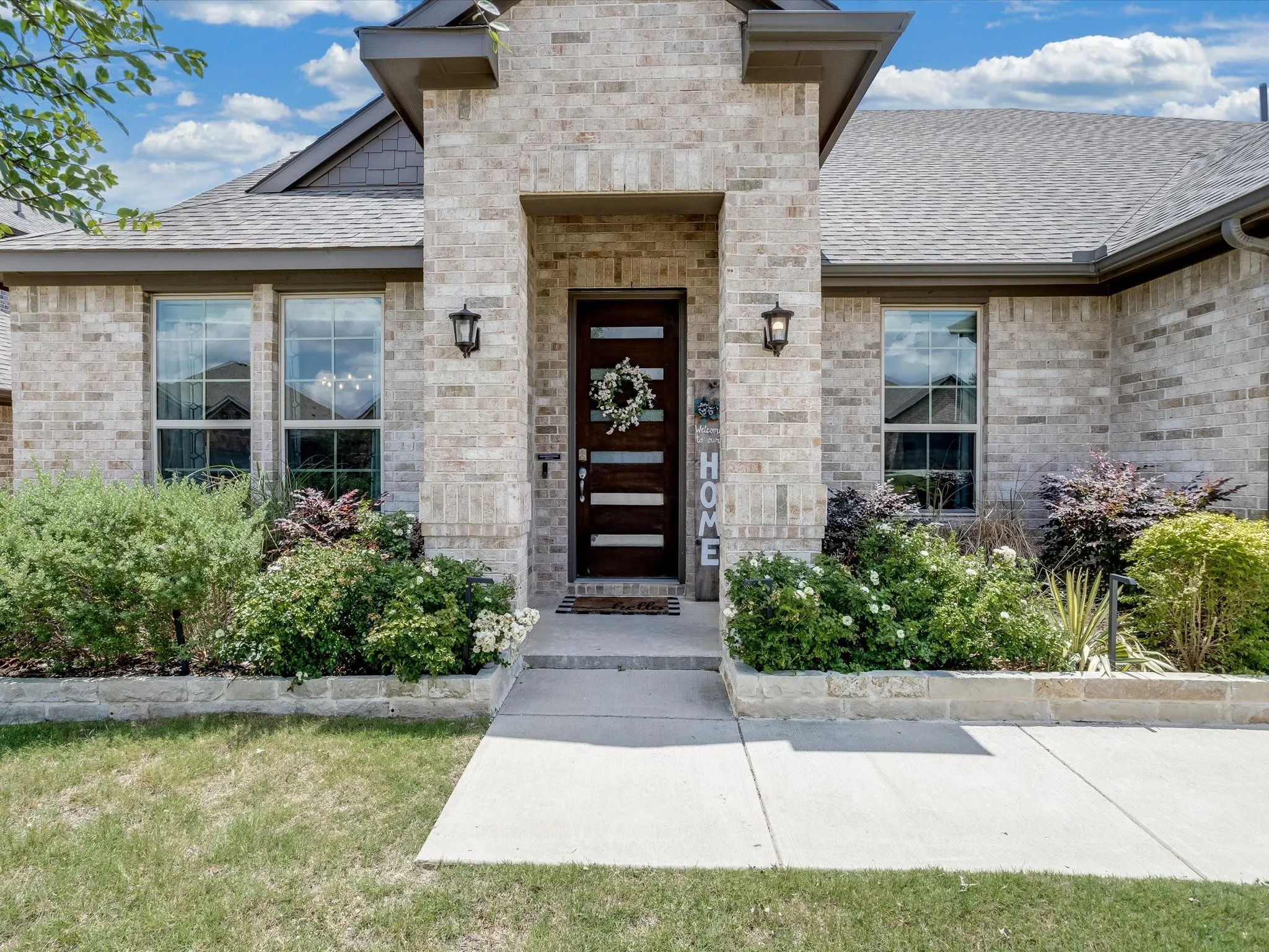 Traditional-style residence featuring a prominent brick facade and a multi-gabled roofline