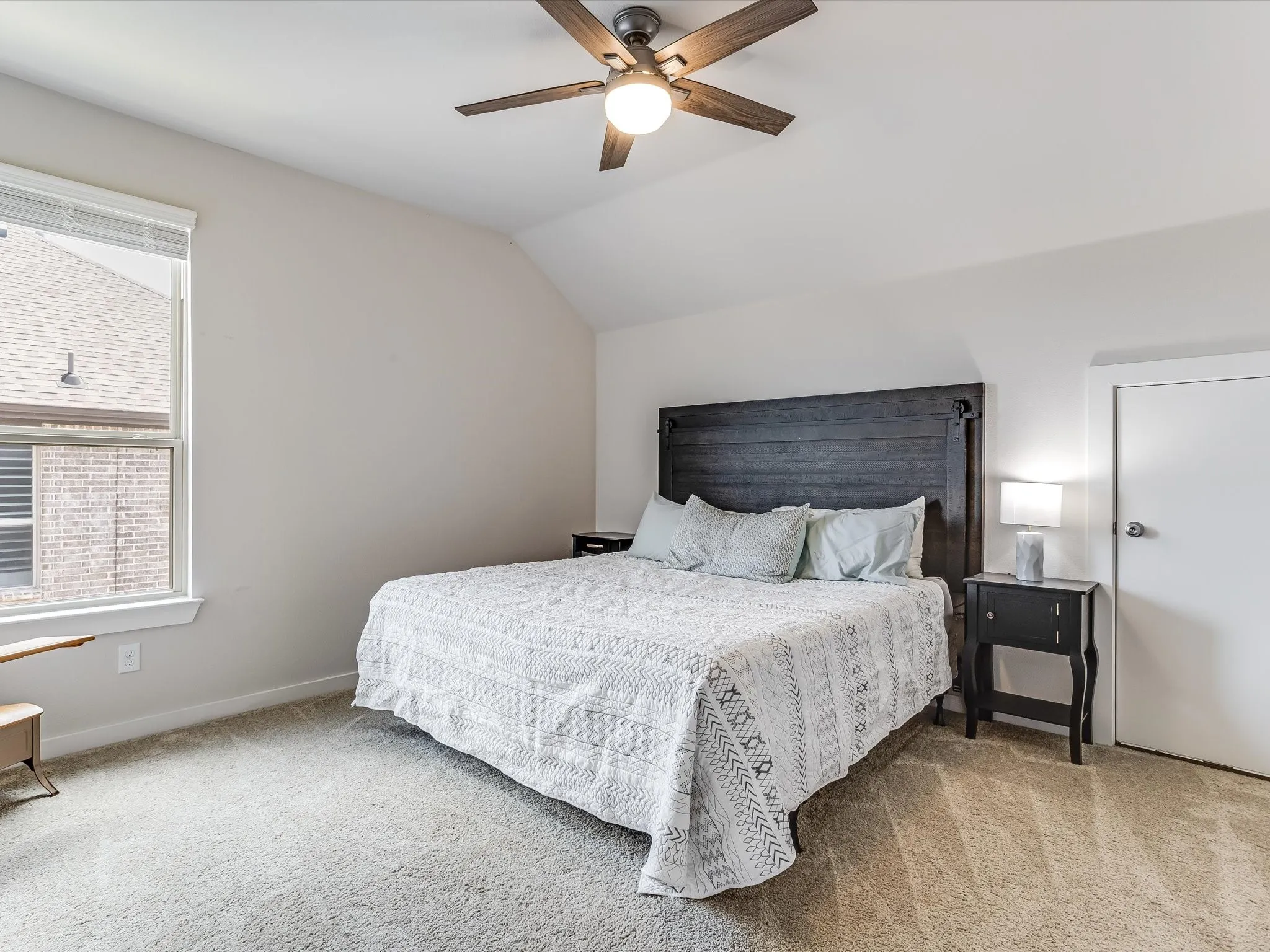 Carpeted room featuring a ceiling fan, a window with blinds, and white painted walls