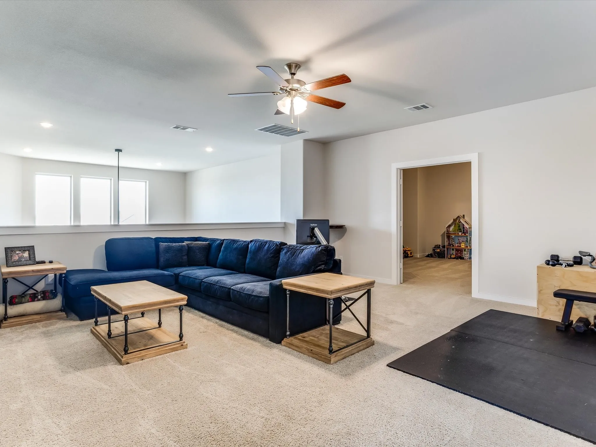 Versatile upper-level space featuring light-colored carpeting, a ceiling fan with integrated lighting, and recessed ceiling lights