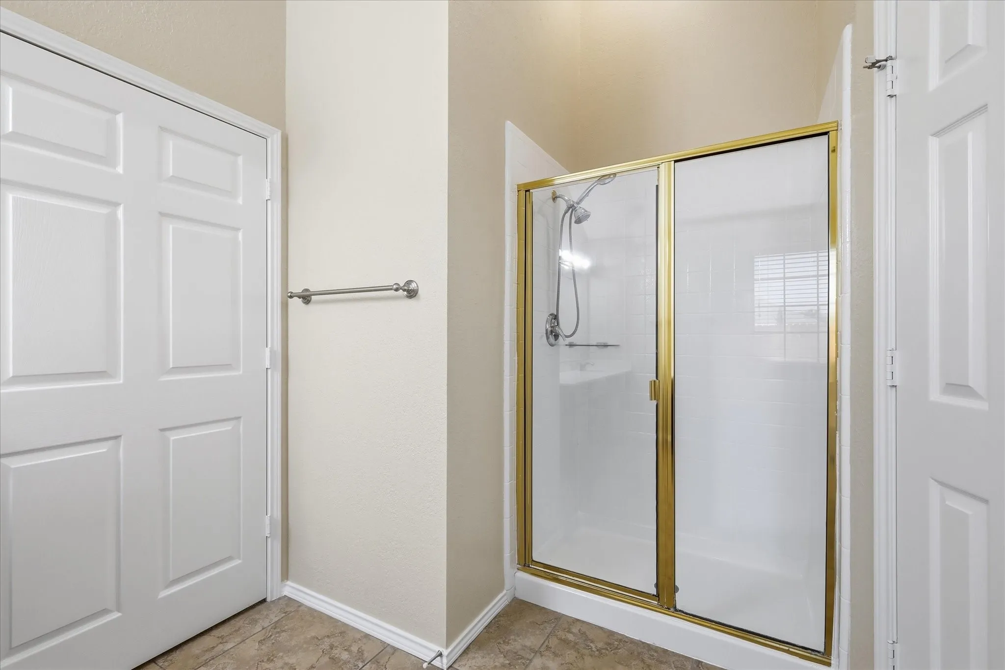 Shower enclosure with brass-finish framing and frosted glass panels