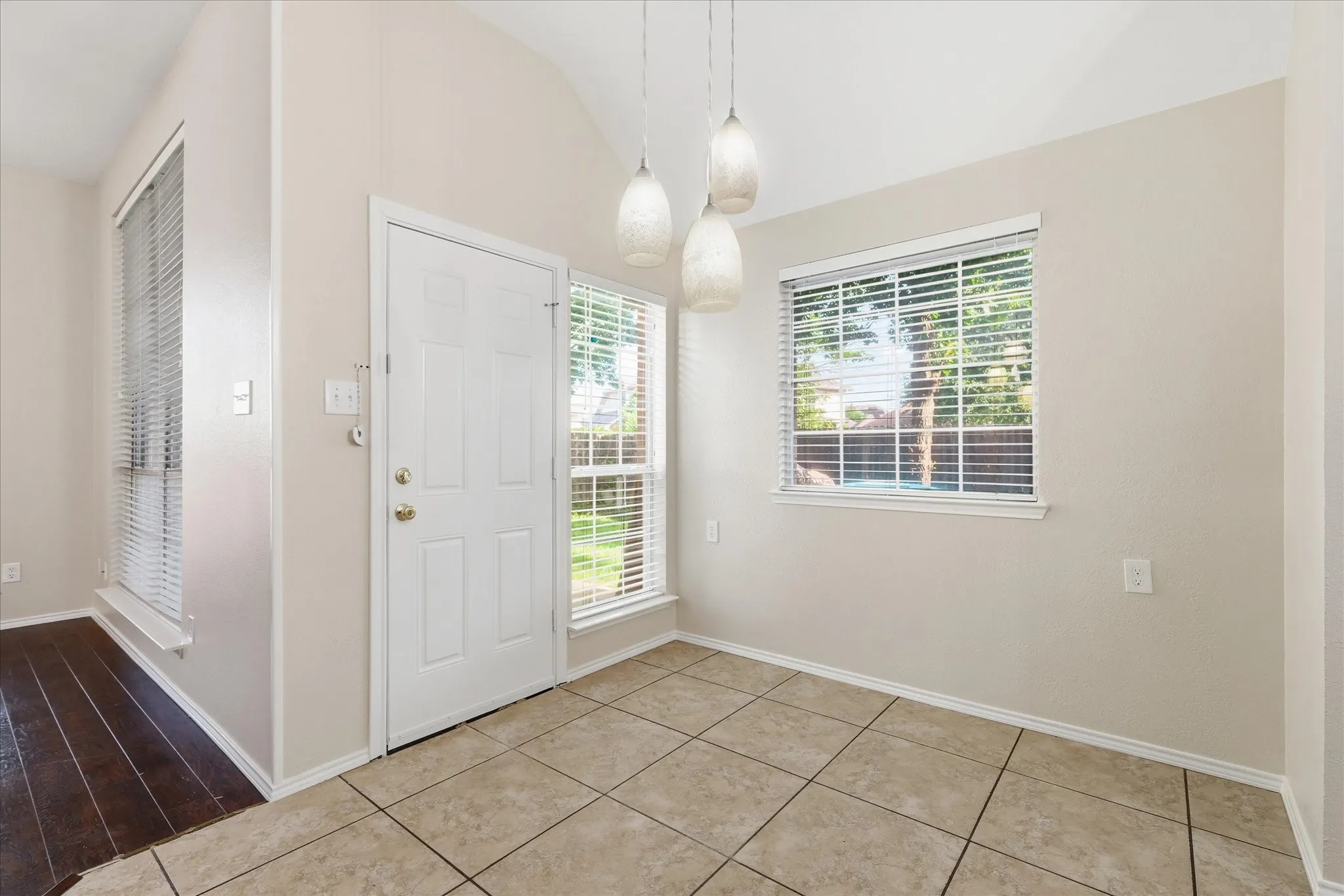 Entryway featuring a vaulted ceiling and a paneled front door