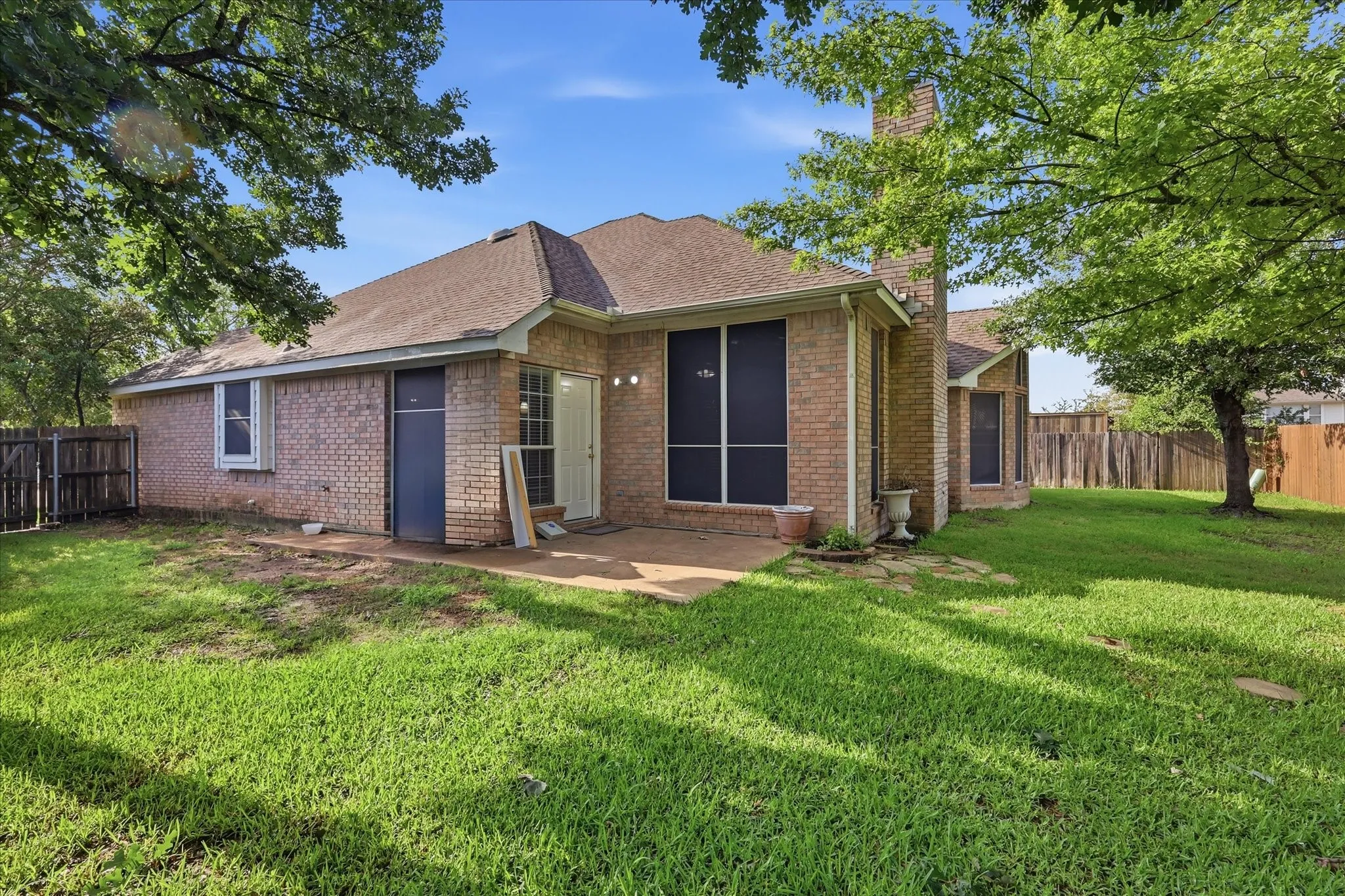 Brick exterior with a gabled roof and a concrete patio