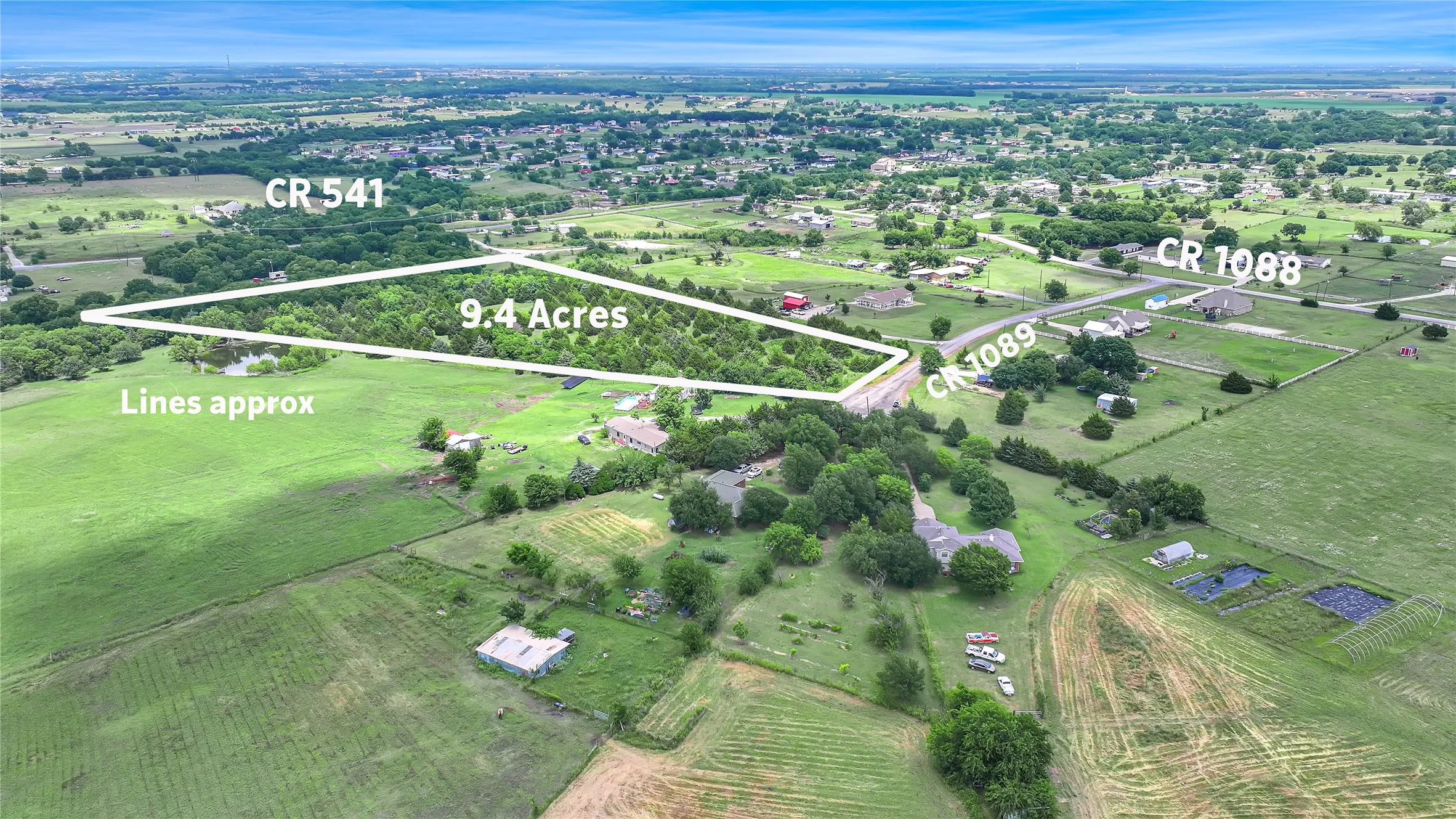 Expansive 9.4-acre lot featuring wooded areas and open green spaces