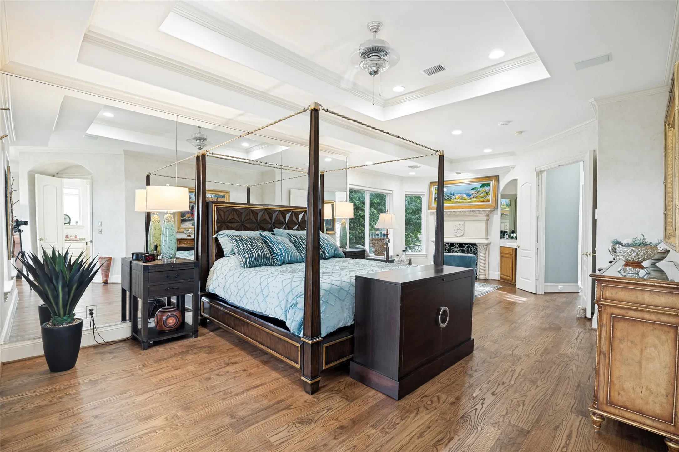 Primary Bedroom with wood floors two sitting areas, one with fireplace and bar area the other with stunning views of golf course and a walk out bacony