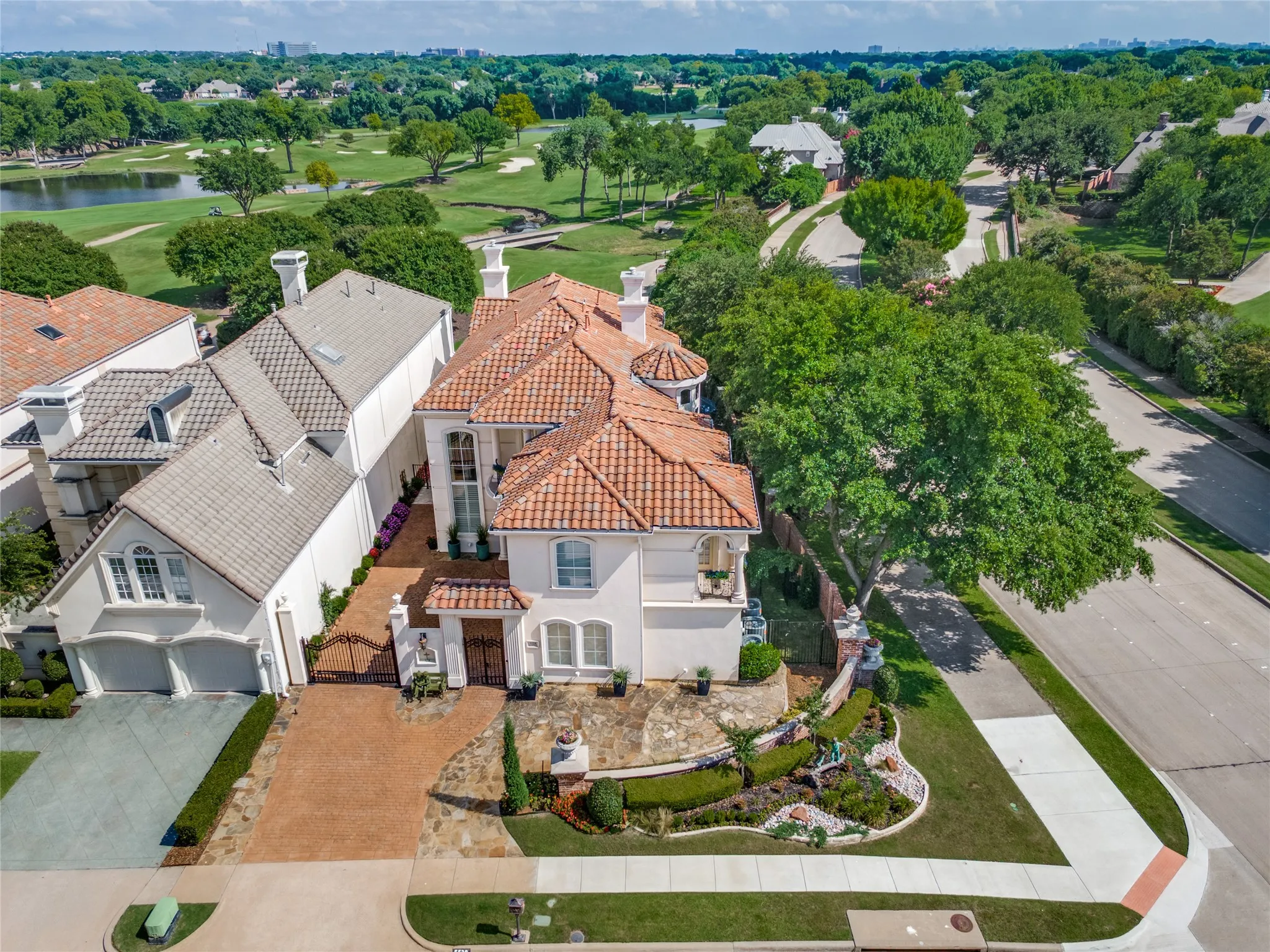 Stucco exterior residence featuring a terracotta-tiled roof and an ornate front entry
