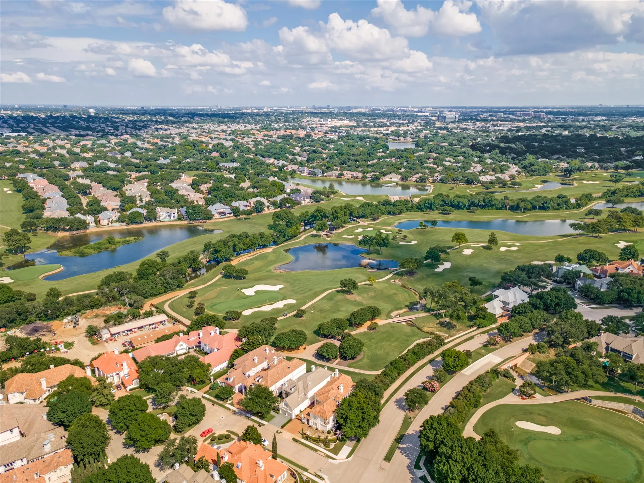 Expansive aerial view showcasing residential properties bordering a manicured golf course