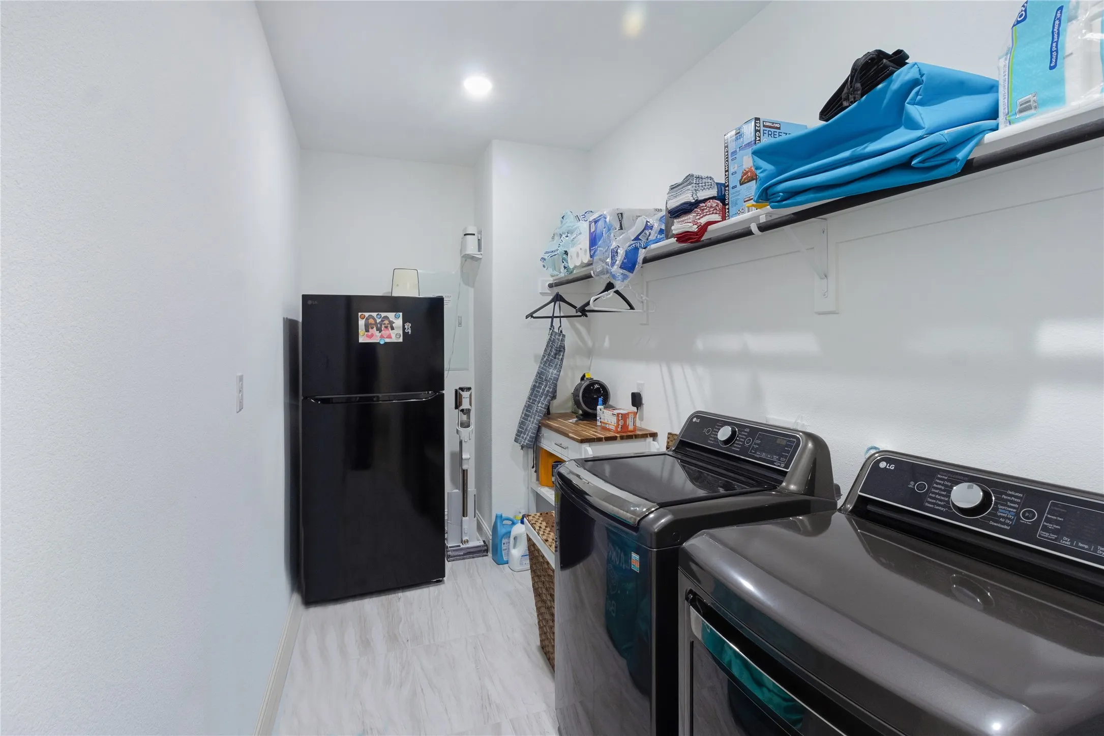 Dedicated laundry room with built-in shelving and additional storage space.