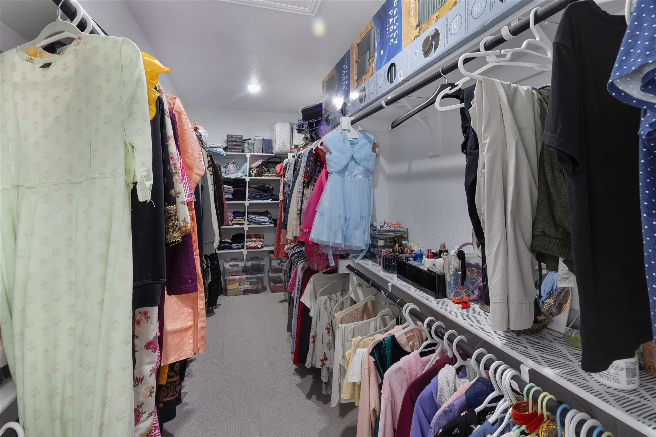 Walk-in closet featuring extensive built-in shelving, multiple hanging rods, and recessed lighting