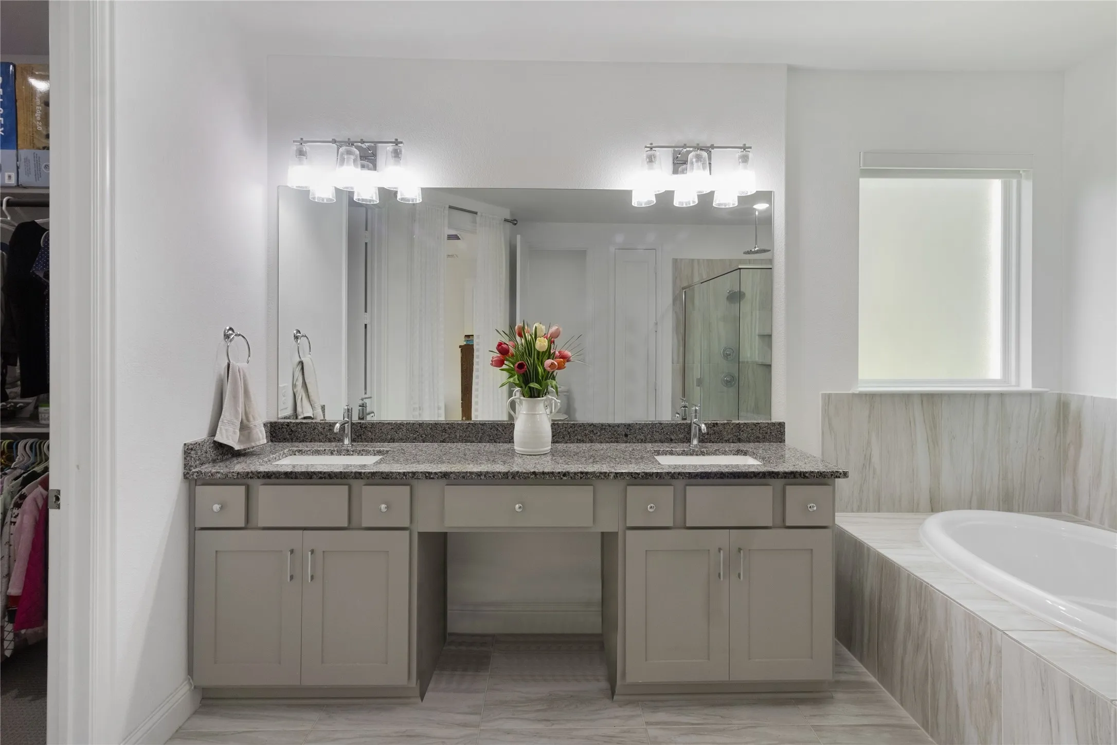 Bathroom featuring a dual vanity with a granite countertop, undermount sinks, and contemporary light fixtures
