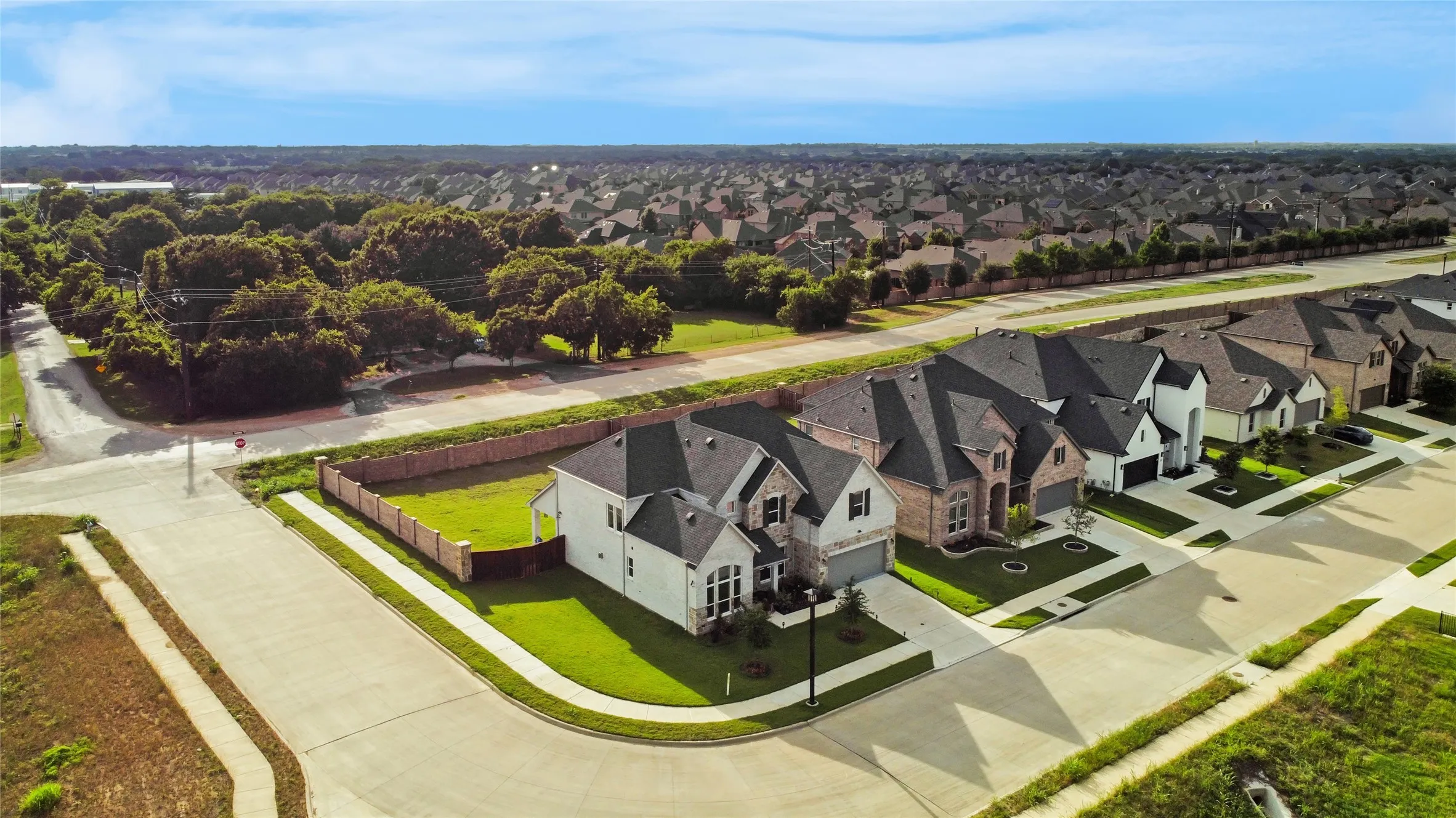 Corner lot residence featuring a two-story design with a white facade and stone accents