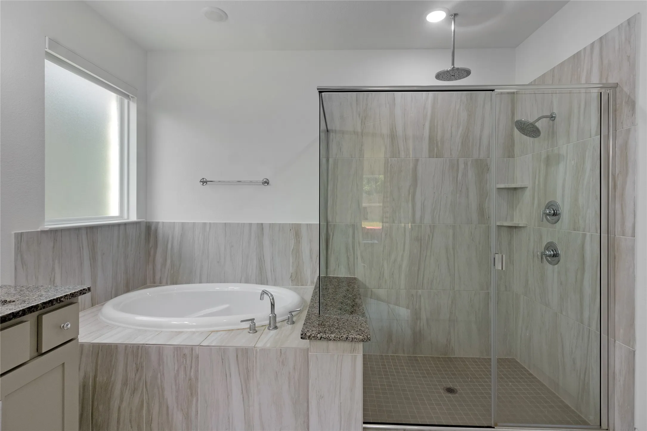 Modern bathroom featuring a built-in soaking tub, a frameless glass shower enclosure, and light-toned tile surrounds