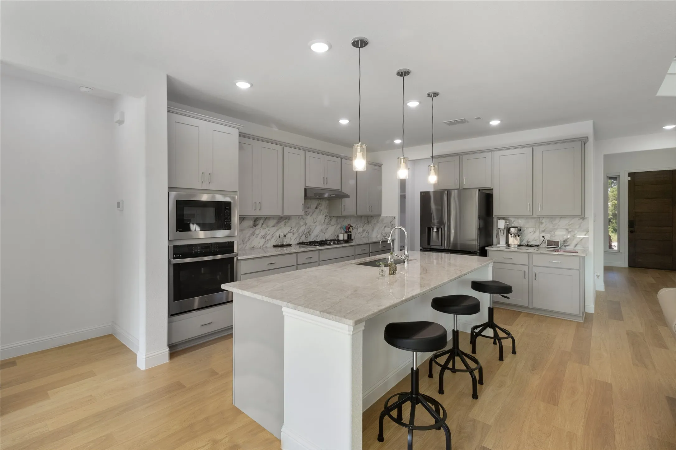 Kitchen featuring light wood-finish flooring, recessed lighting, and an island with pendant lights