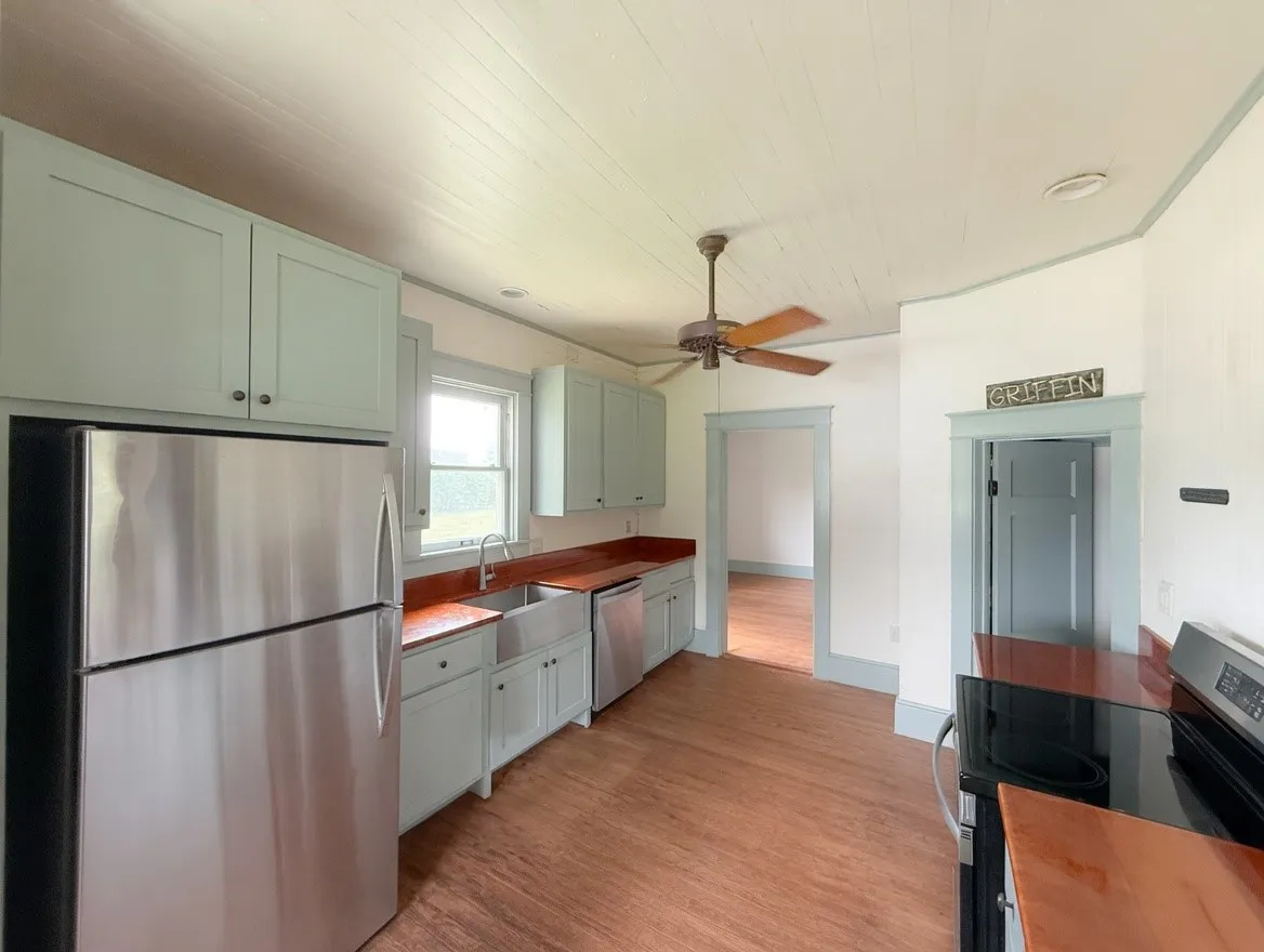 Kitchen featuring light-toned cabinetry, wood-finish countertops, and wood-finish flooring