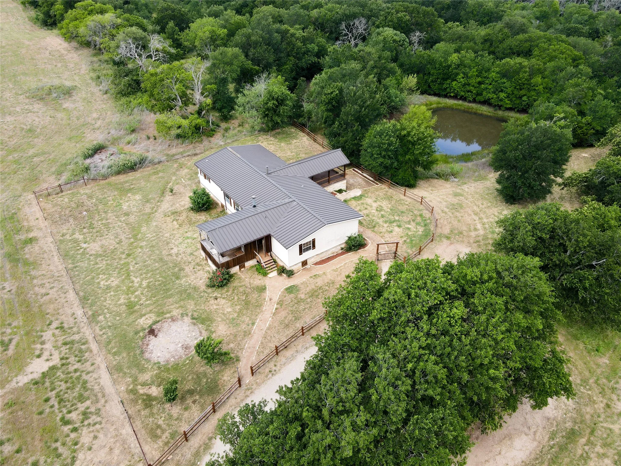 Aerial perspective showcasing a single-story residence with a dark metal roof