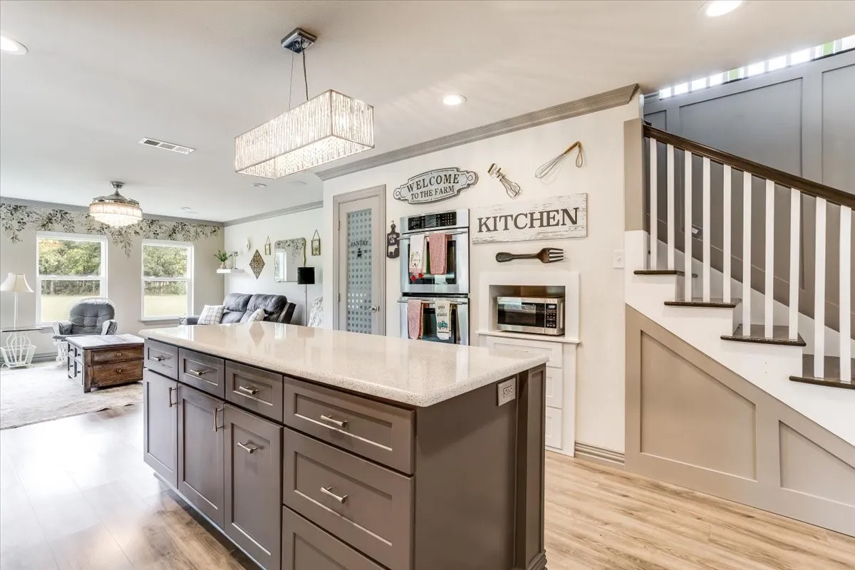 Expansive kitchen island with wood-finish cabinetry and a light-toned countertop