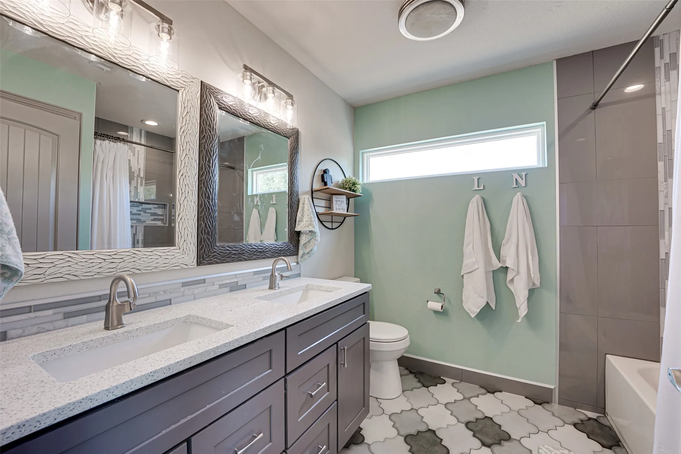 upstairs bathroom featuring a dual vanity with undermount sinks, speckled white countertops, and dark wood cabinetry