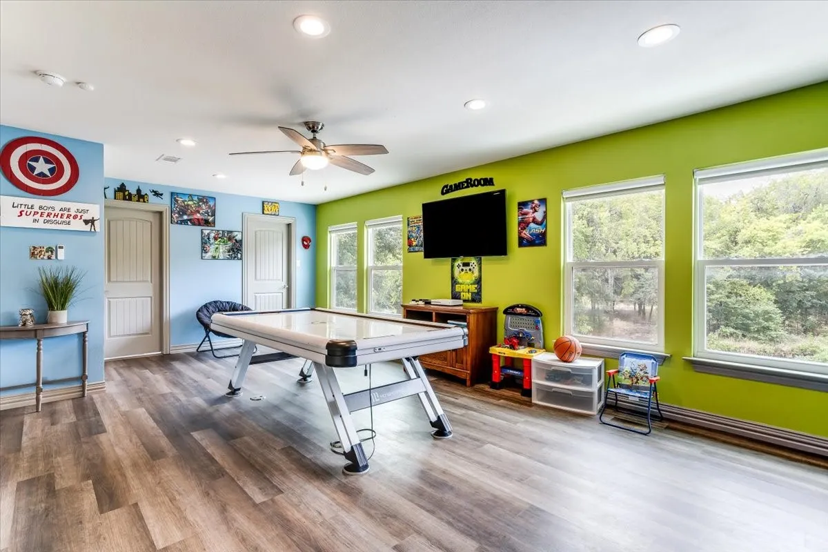 Spacious room featuring wood-finish flooring, recessed lighting, and a ceiling fan