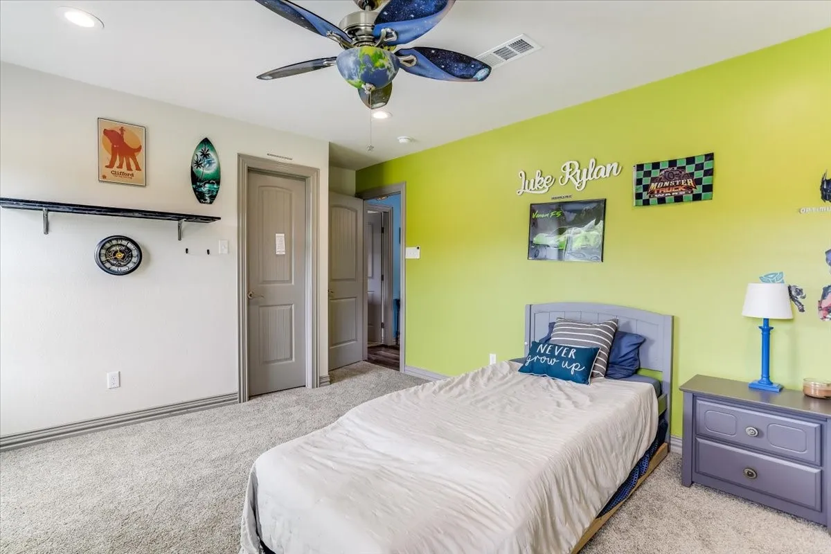 Carpeted room featuring a lime green accent wall, recessed lighting, and a ceiling fan