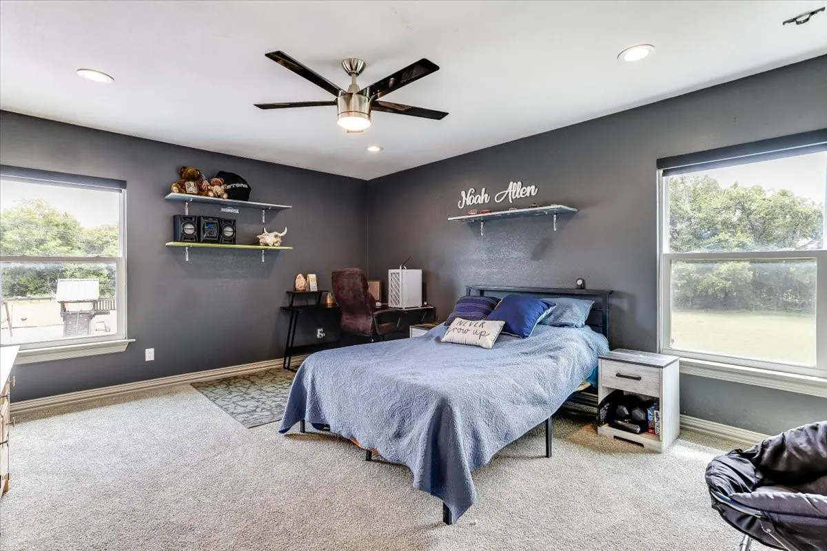 Carpeted room featuring multiple windows, recessed lighting, and a ceiling fan with integrated illumination