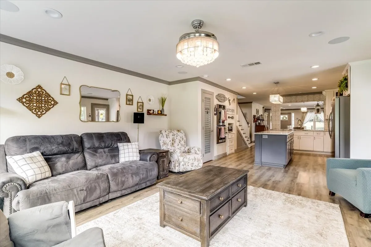 Open-concept living space with wood-finish flooring, recessed lighting, and a decorative ceiling fixture