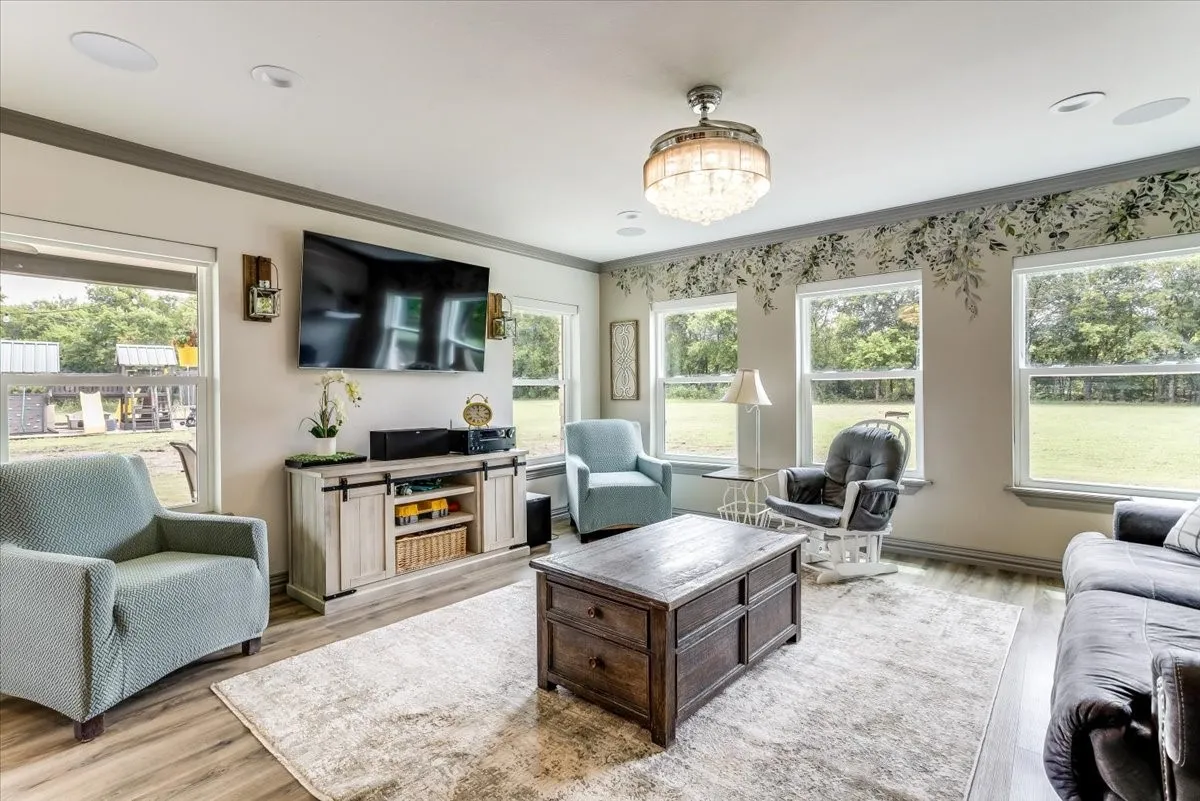 Spacious living area featuring wood-finish flooring and a central area rug