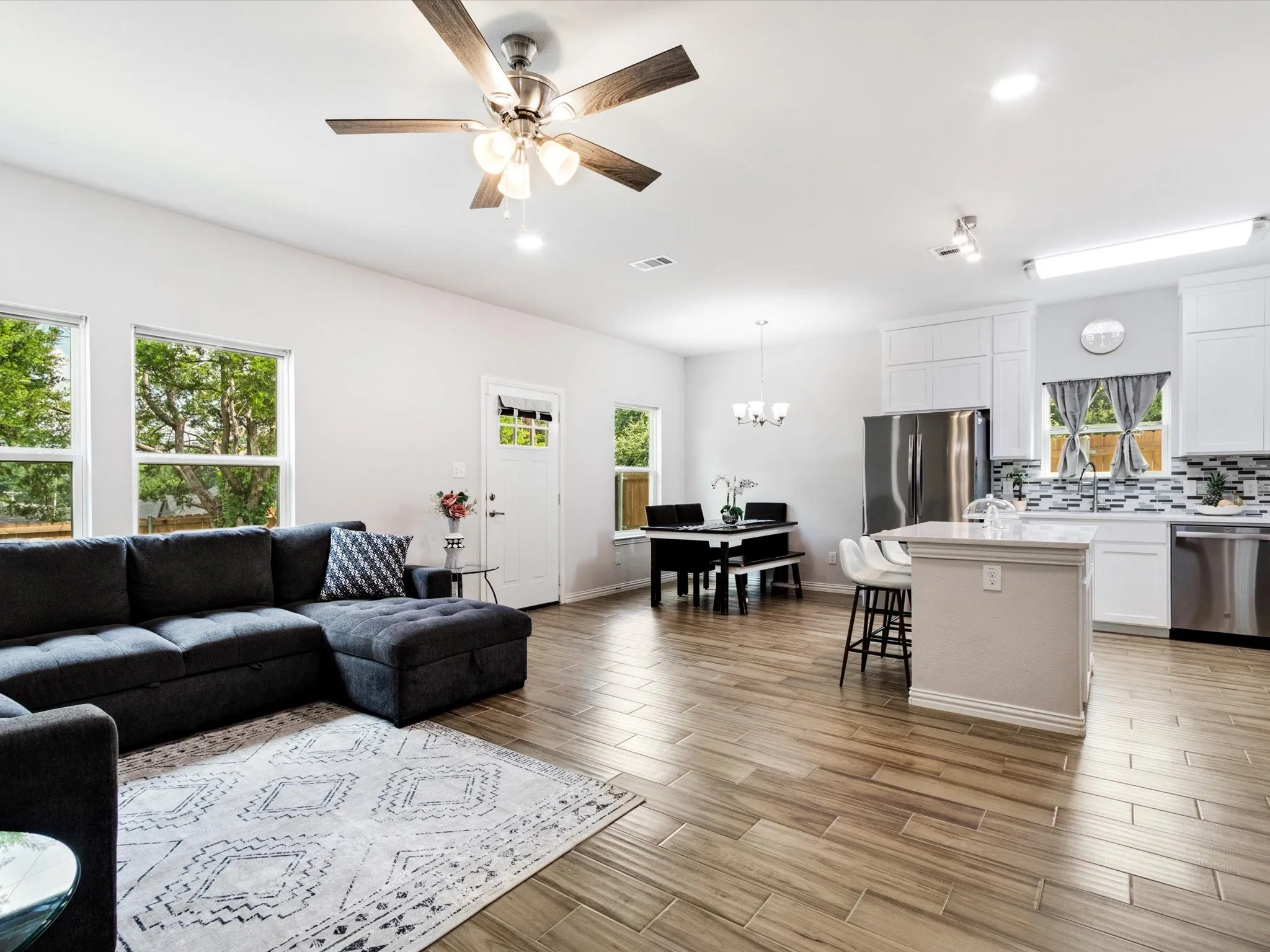 Open-concept living space featuring wood-finish flooring, recessed lighting, and a modern ceiling fan