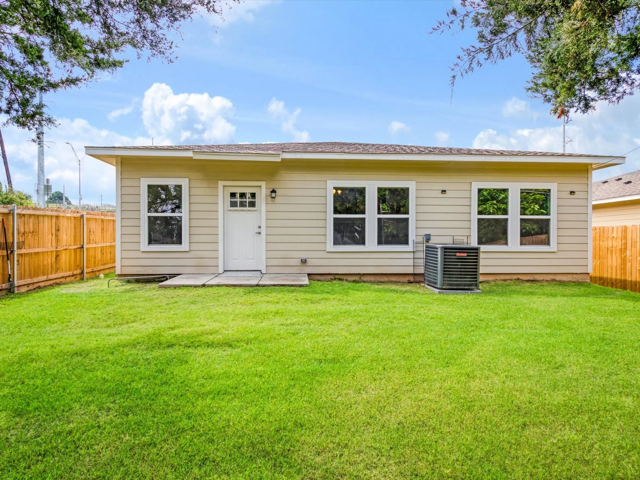 Expansive green lawn with a privacy fence