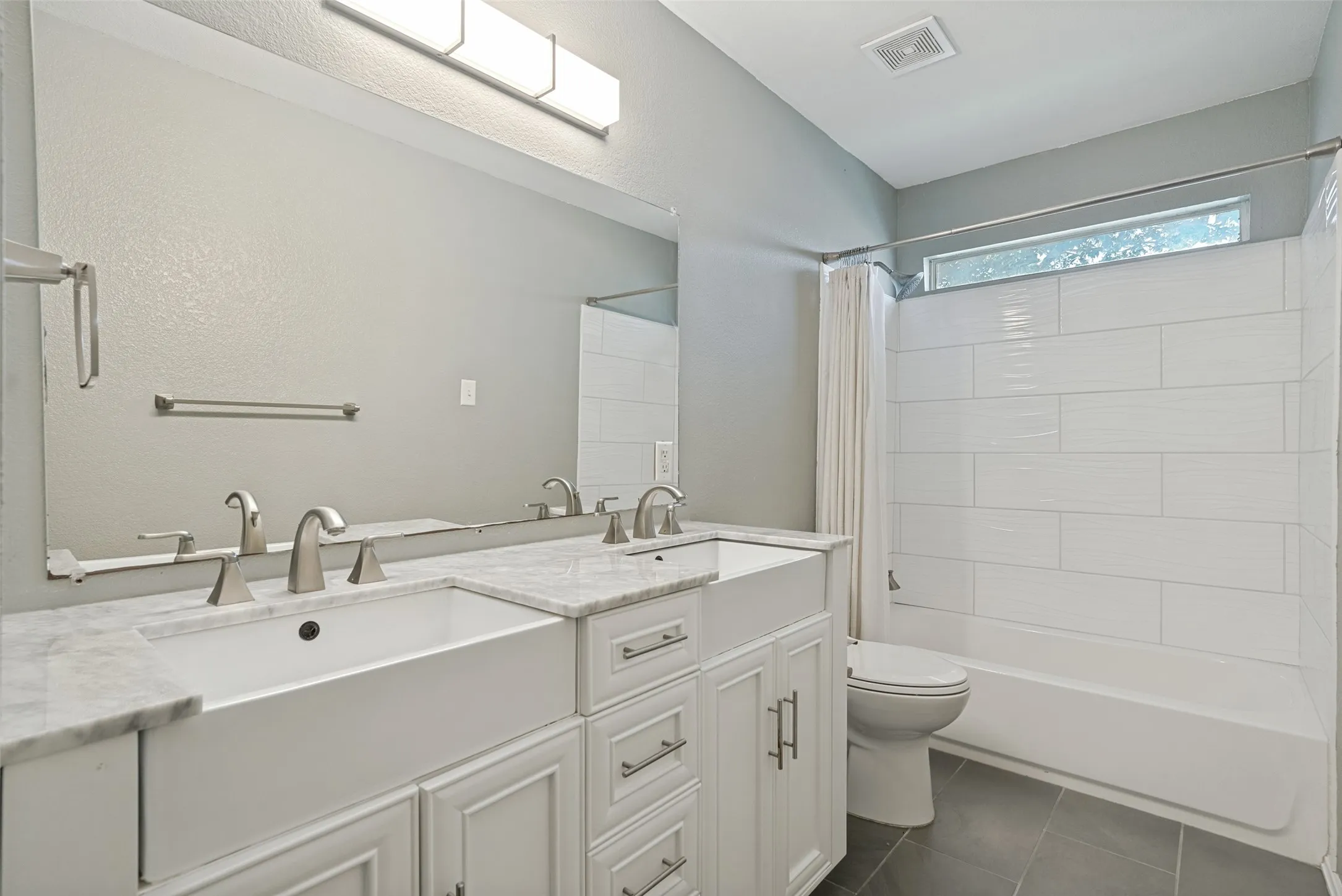 Dual vanity with undermount sinks and light-colored countertops