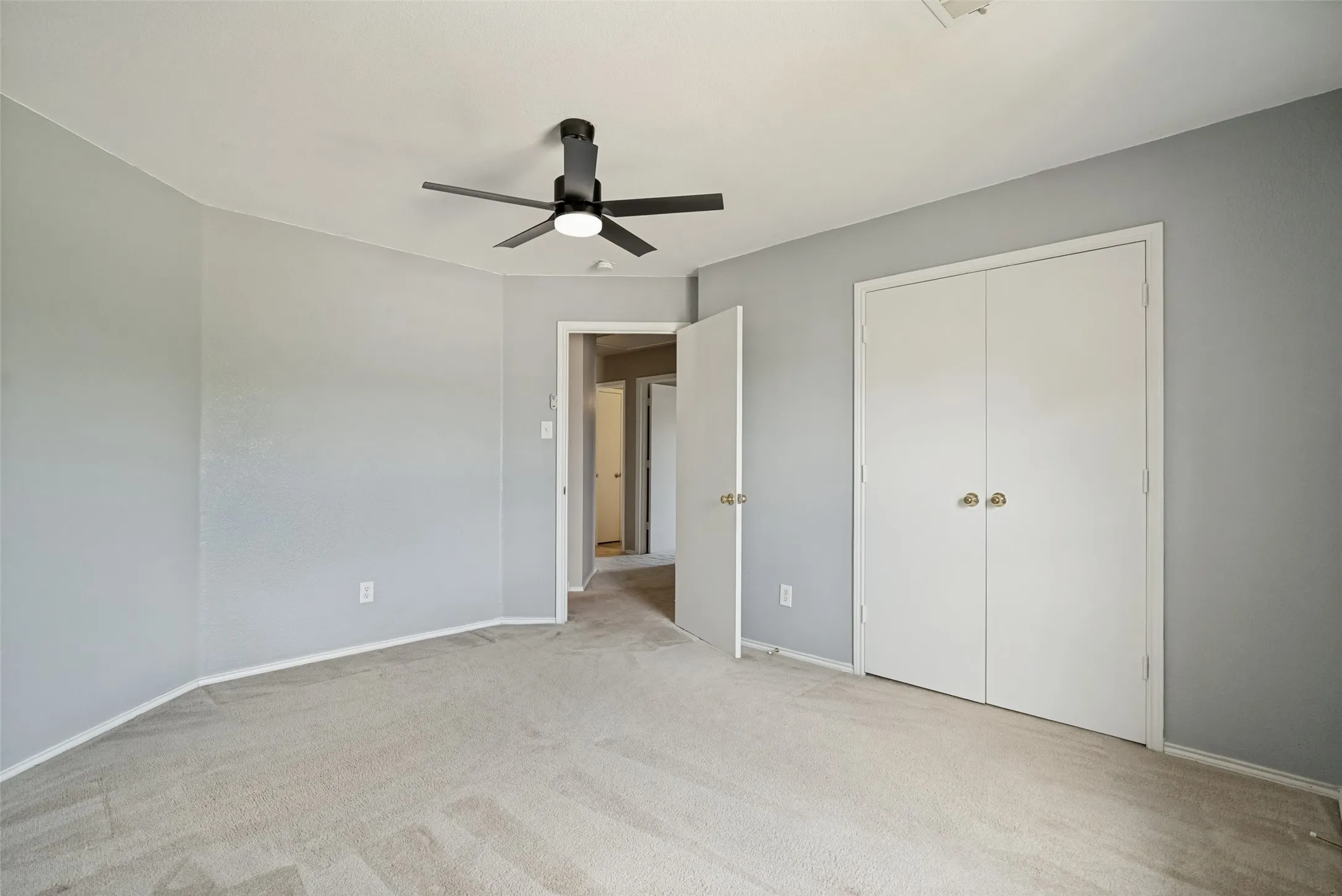 Carpeted interior room with light gray wall paint and white trim