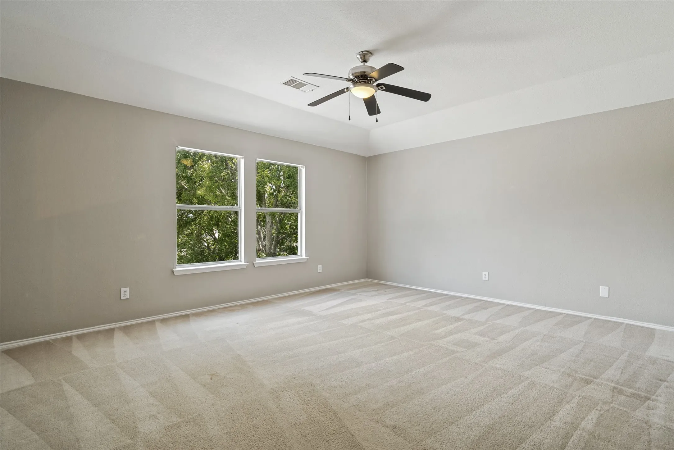 Spacious room featuring neutral carpeting and light-toned wall paint