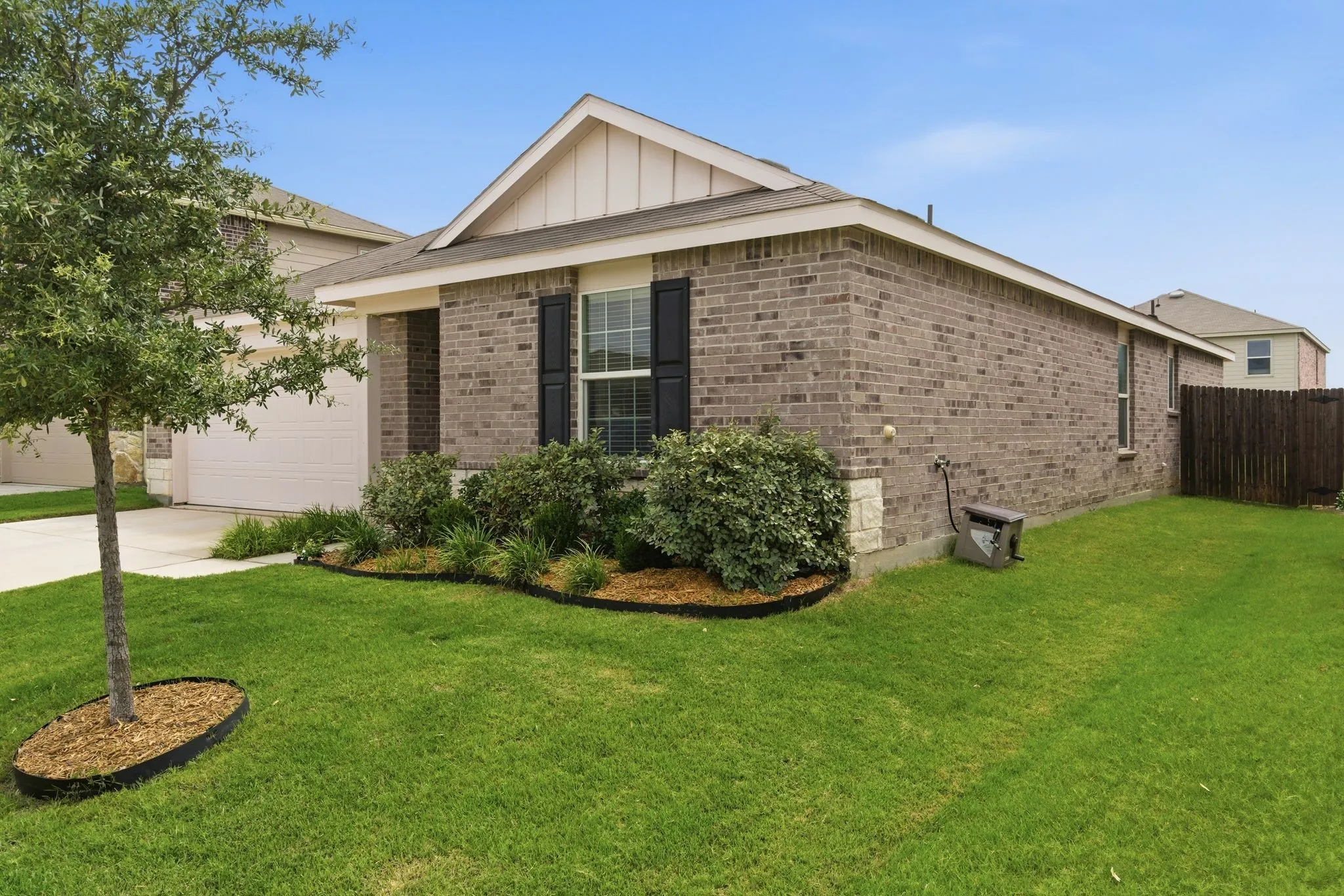 Brick exterior with a gabled roofline, decorative window shutters, and a two-car garage