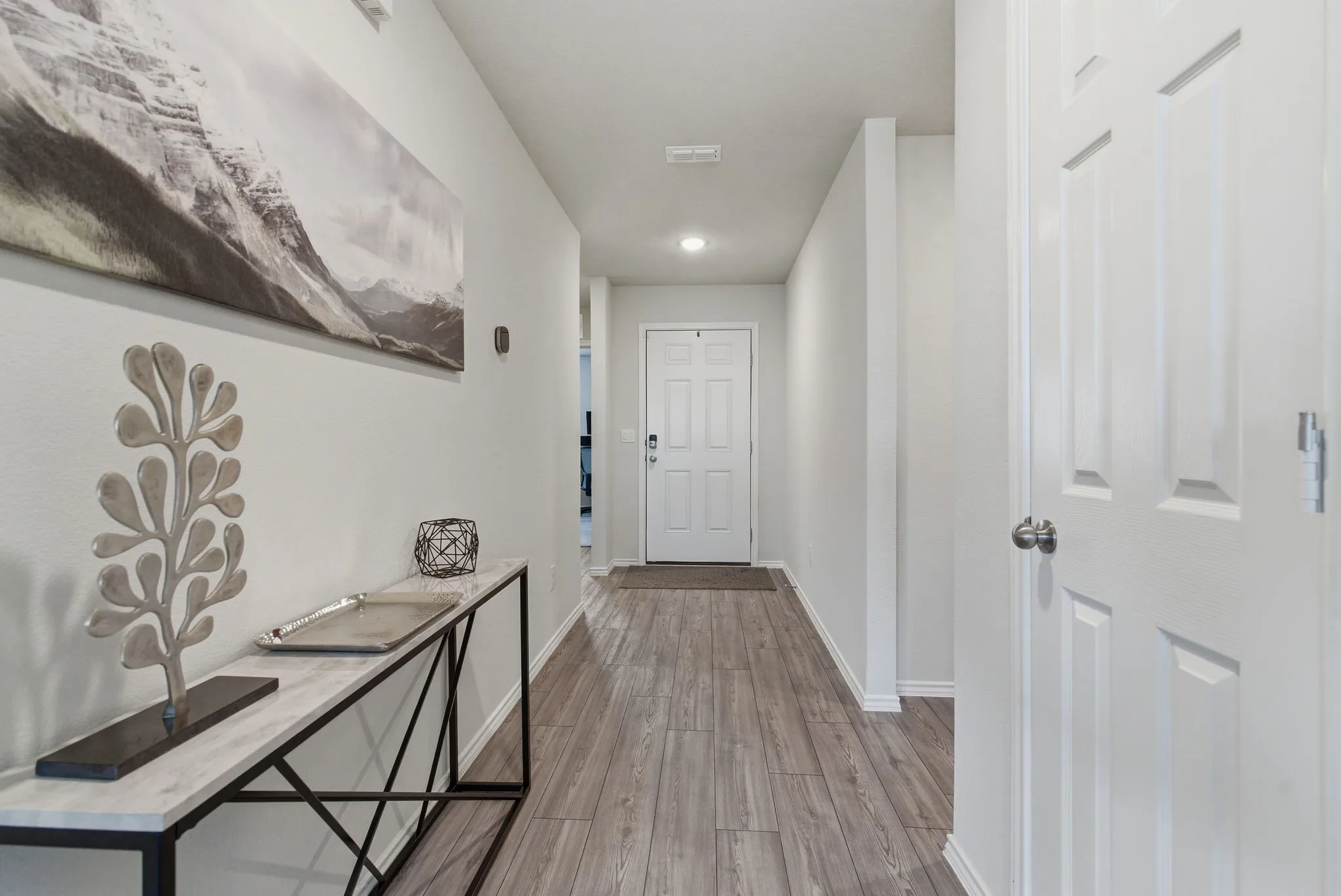 Entryway featuring wood-look tile flooring, recessed lighting, and a paneled interior door