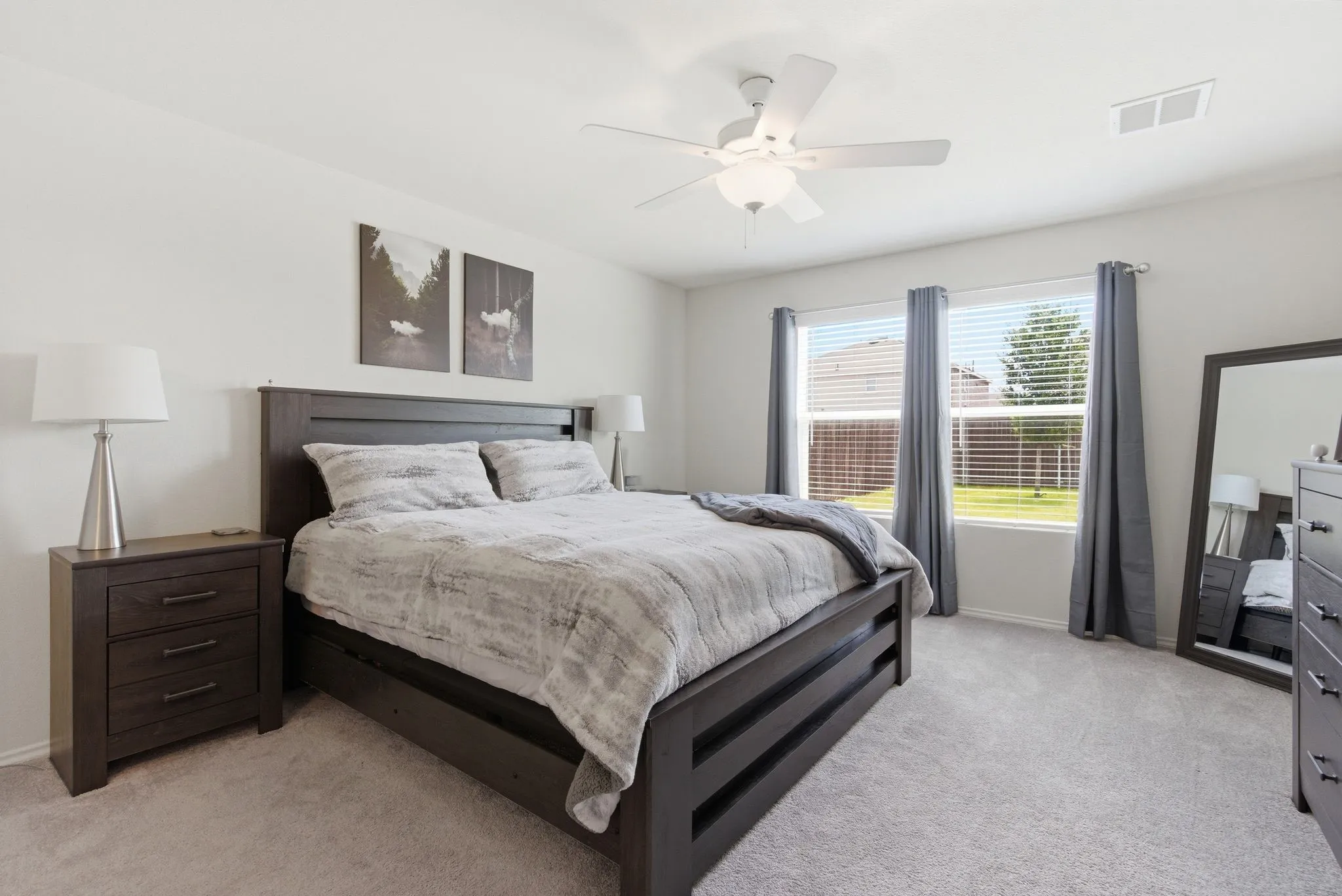 Bright room featuring plush carpeting and a white ceiling fan with integrated lighting