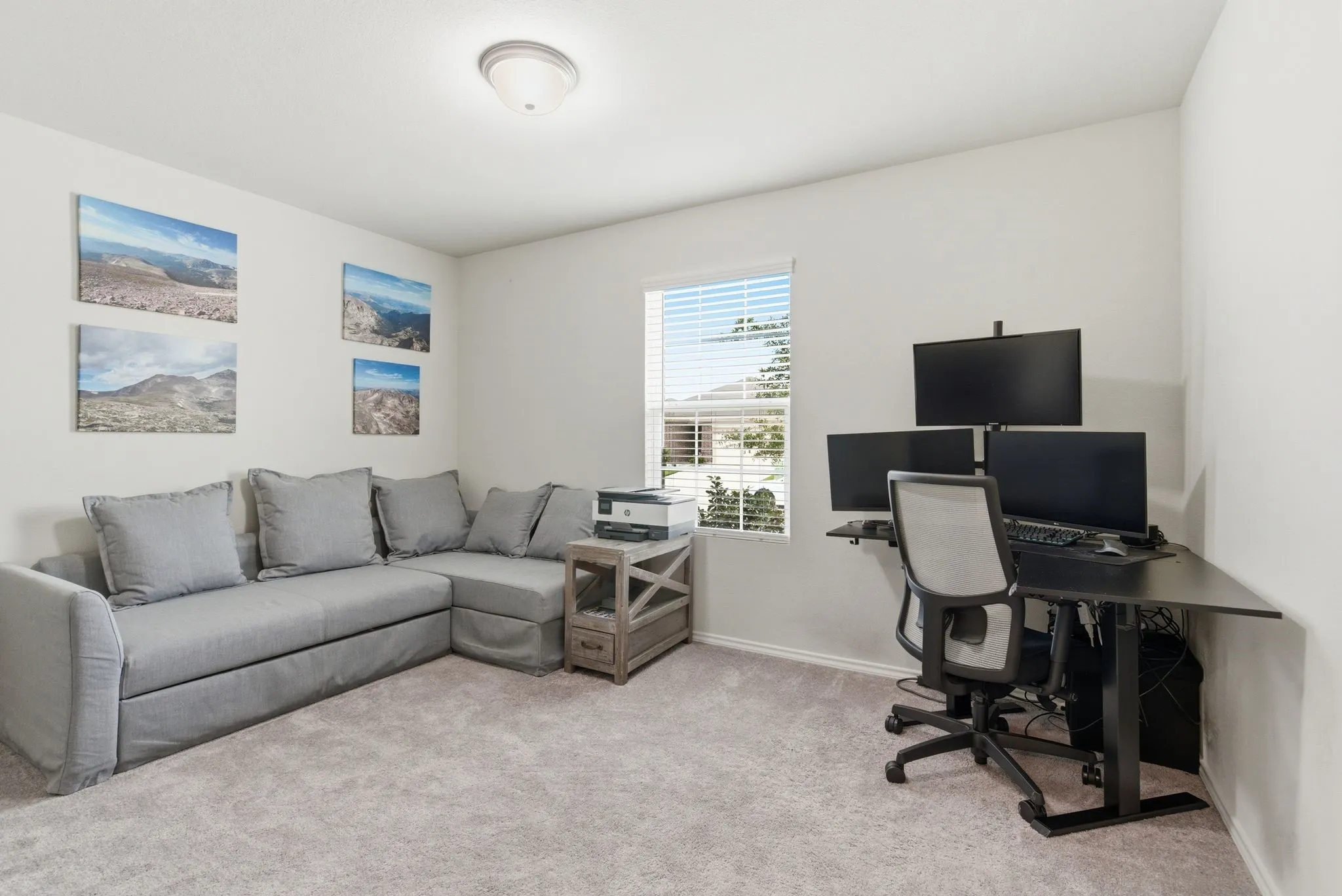 Carpeted room with white walls and a single window with blinds and a walk in closet