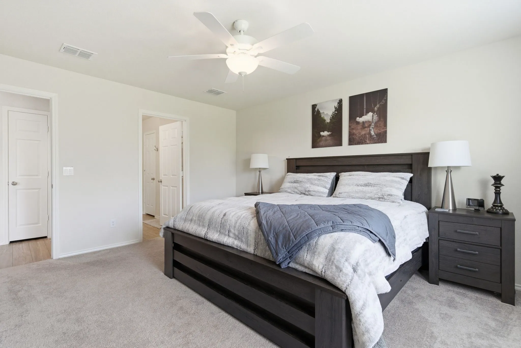 Carpeted primary with ensuite and a ceiling fan