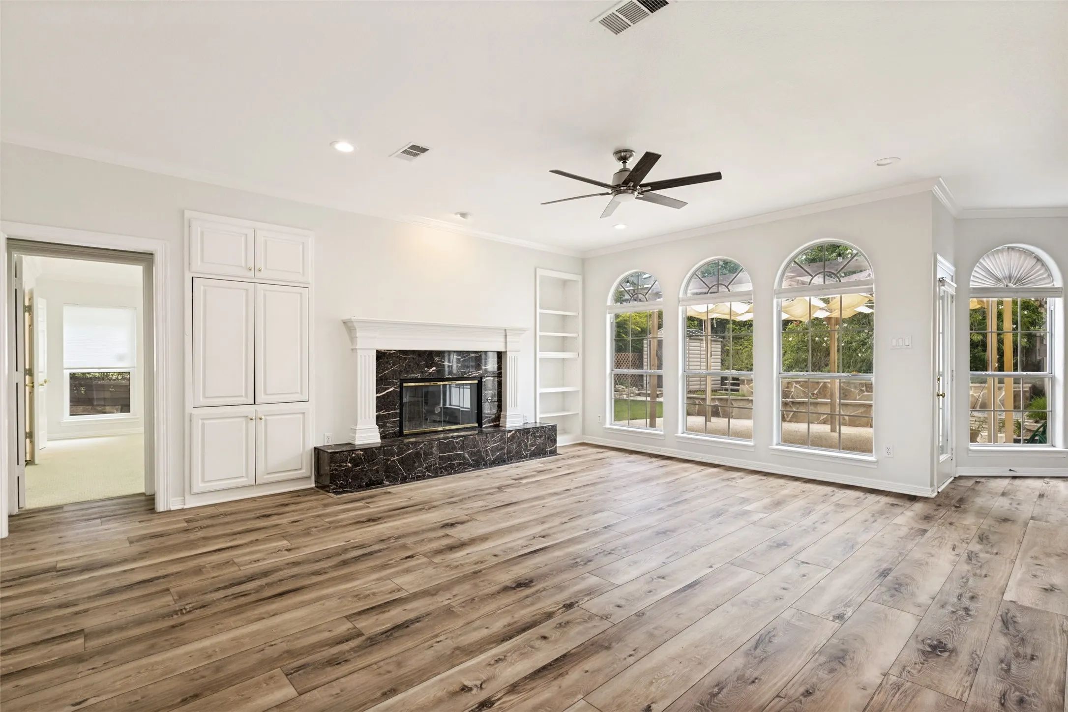 Spacious room with wood-finish flooring, a contemporary ceiling fan, and recessed lighting