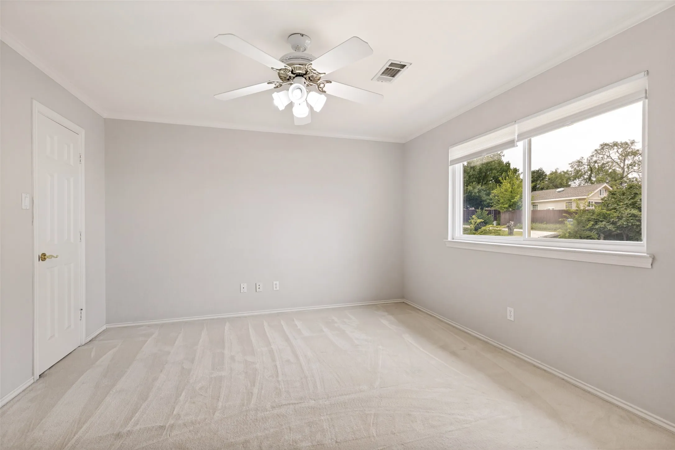 Spacious room featuring neutral carpeting and light-colored walls