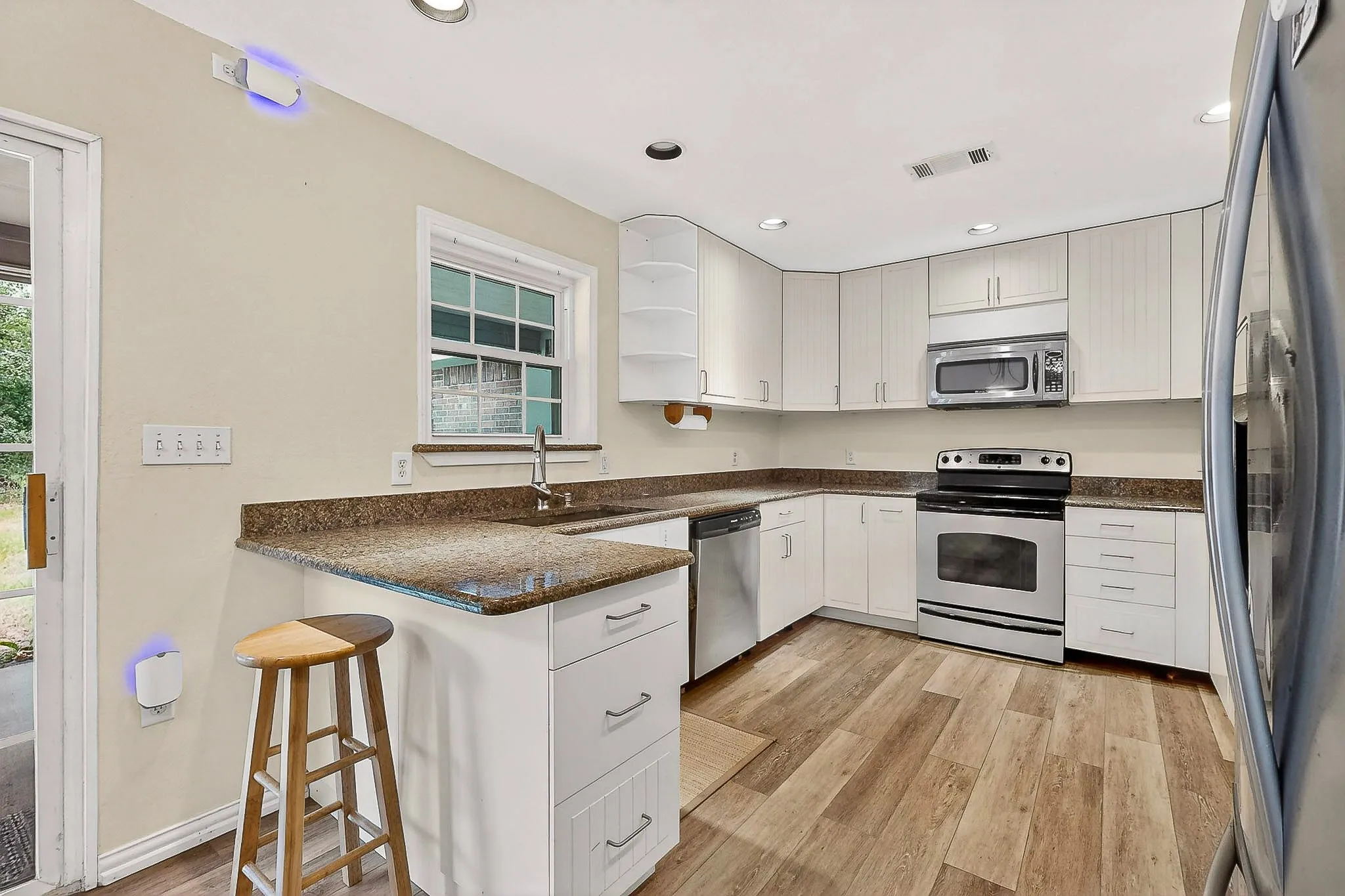 Kitchen with granite countertops and newly installed luxury vinyl flooring.