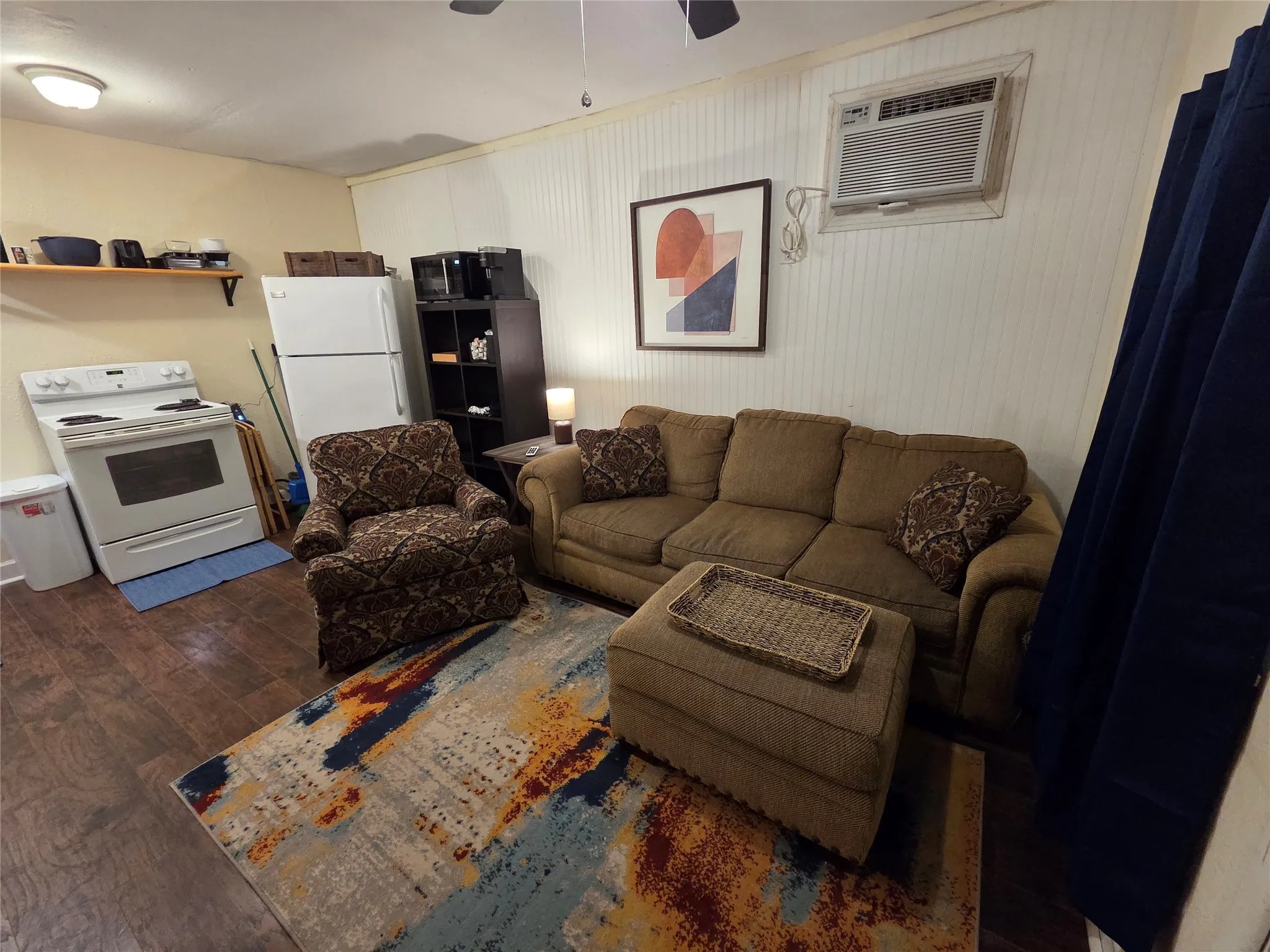 Open floor plan living room and full service kitchen. Wall mounted AC/Heating unit. **PLEASE NOTE WE ARE WILLING TO TAKE OUT FURNISHINGS IF YOU ARE INTERESTED IN AN UNFURNISHED RENTAL AT A LOWER RATE**