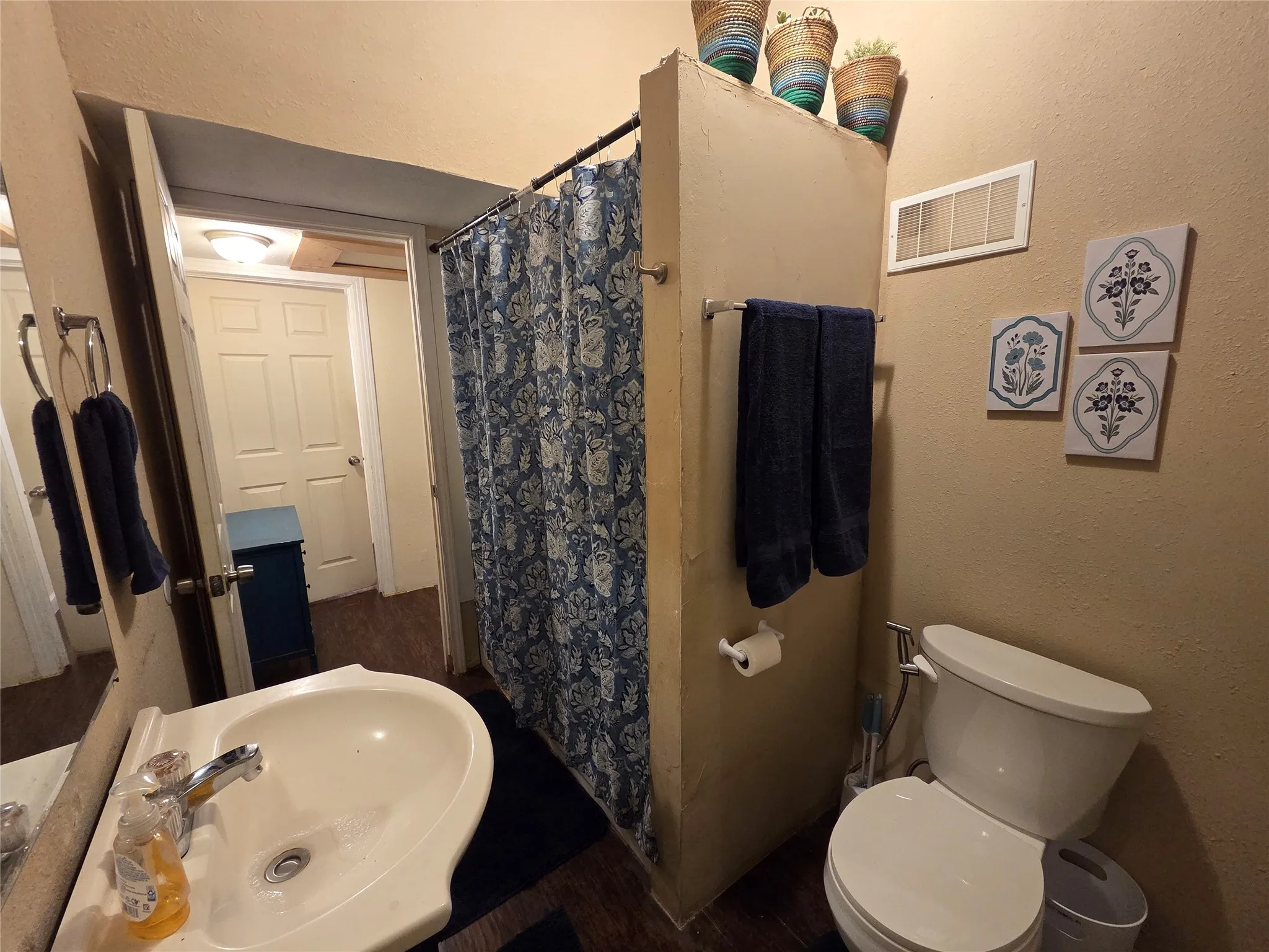 Bathroom with tub/shower combo, vanity, commode, and full size washer and dryer