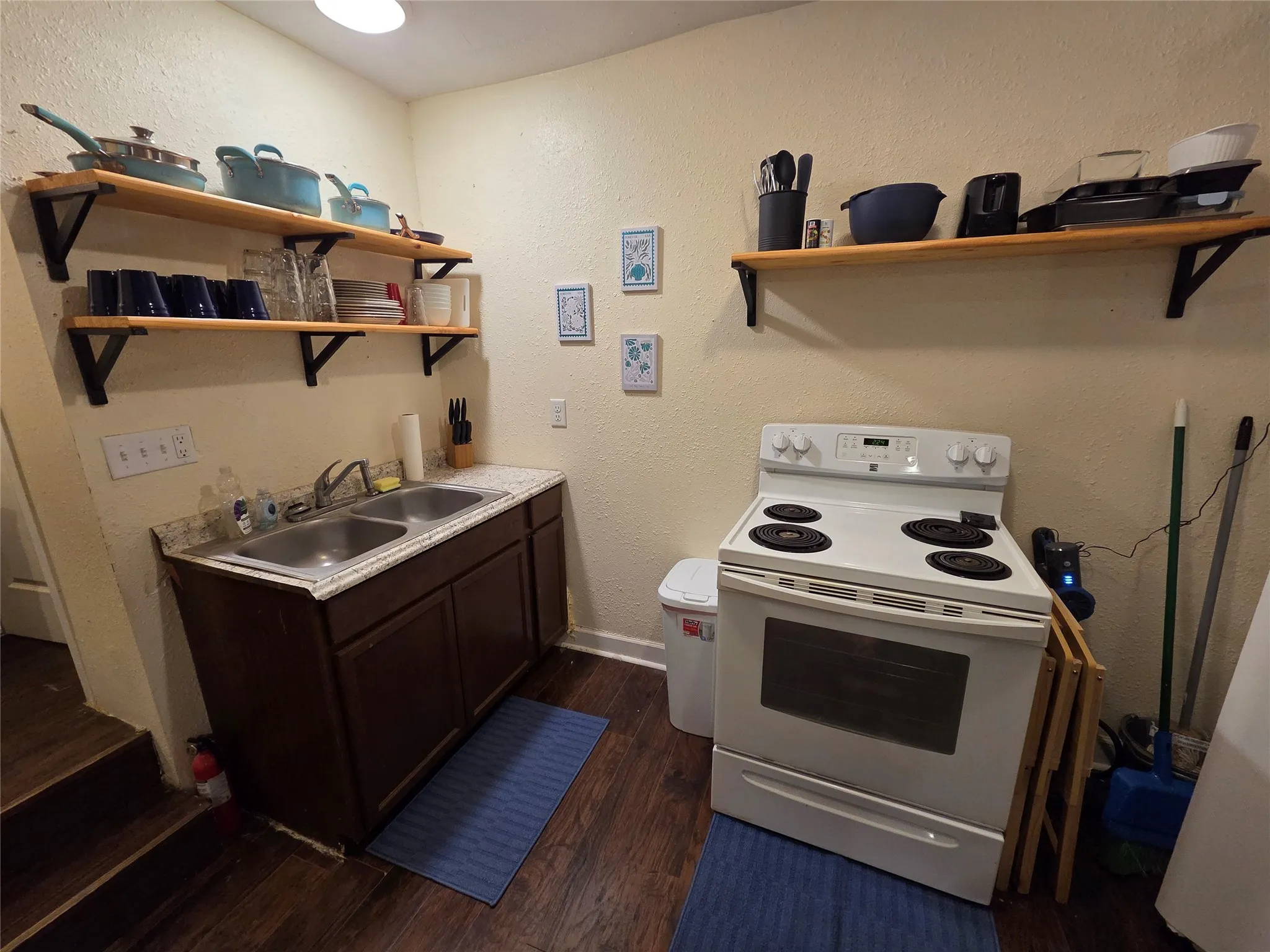 Full service kitchen including electric range, fridge, microwave, toaster, and Keurig. Kitchen is stocked with everything you need to cook and serve a meal.
