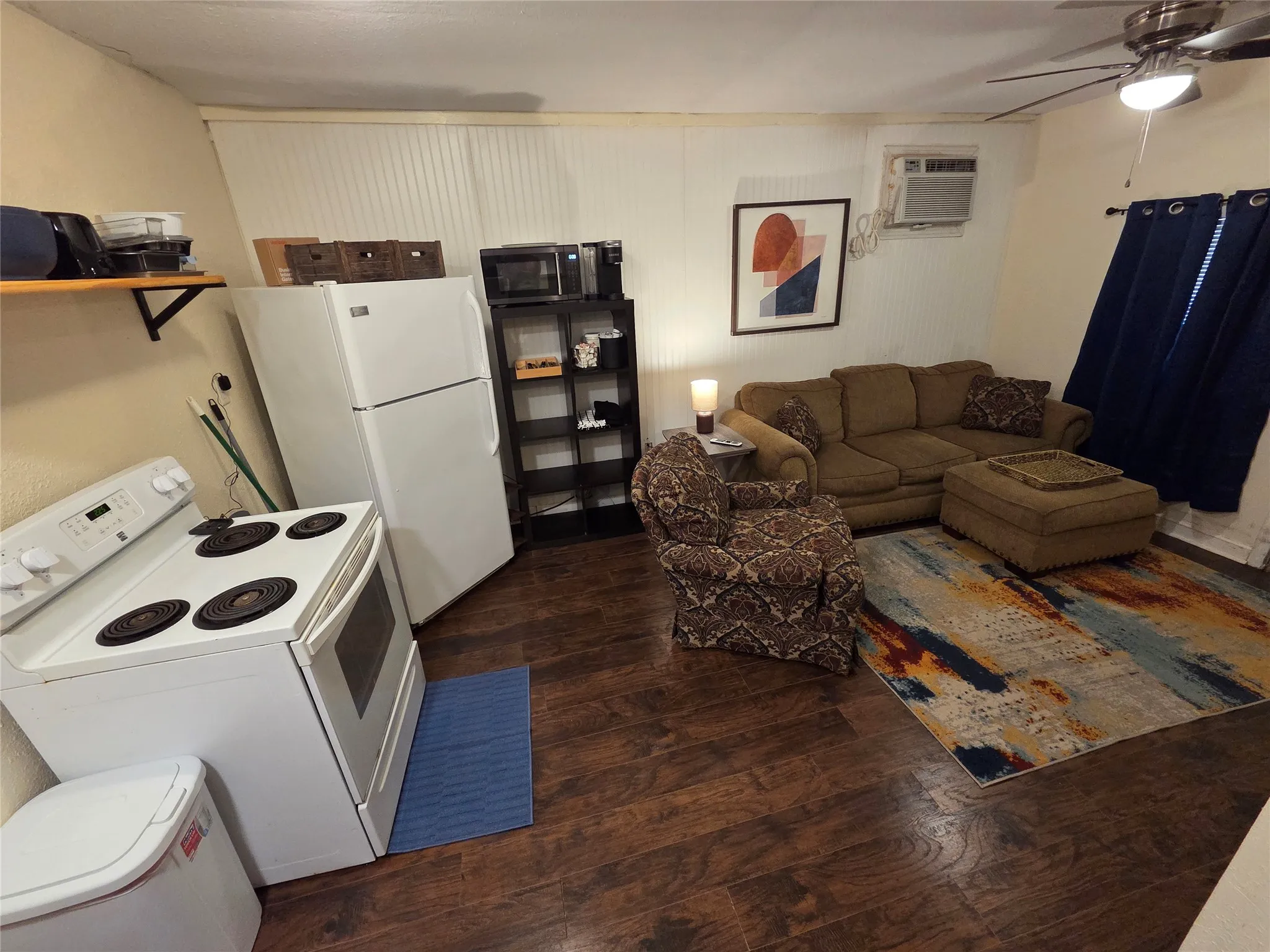 Open floor plan living room and full service kitchen. Wall mounted AC/Heating unit. **PLEASE NOTE WE ARE WILLING TO TAKE OUT FURNISHINGS IF YOU ARE INTERESTED IN AN UNFURNISHED RENTAL AT A LOWER RATE**