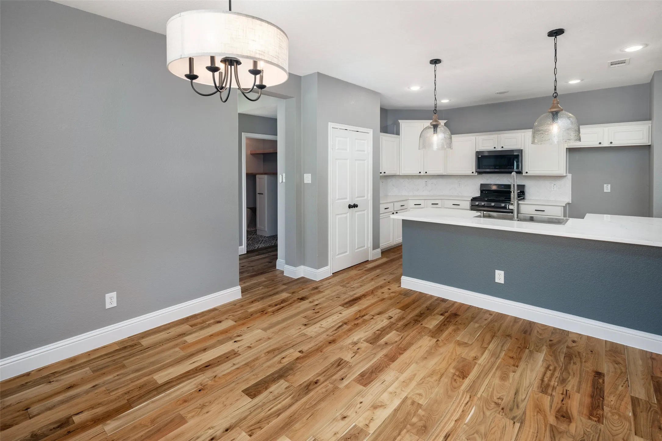 Open-concept kitchen and dining area featuring wood-finish flooring