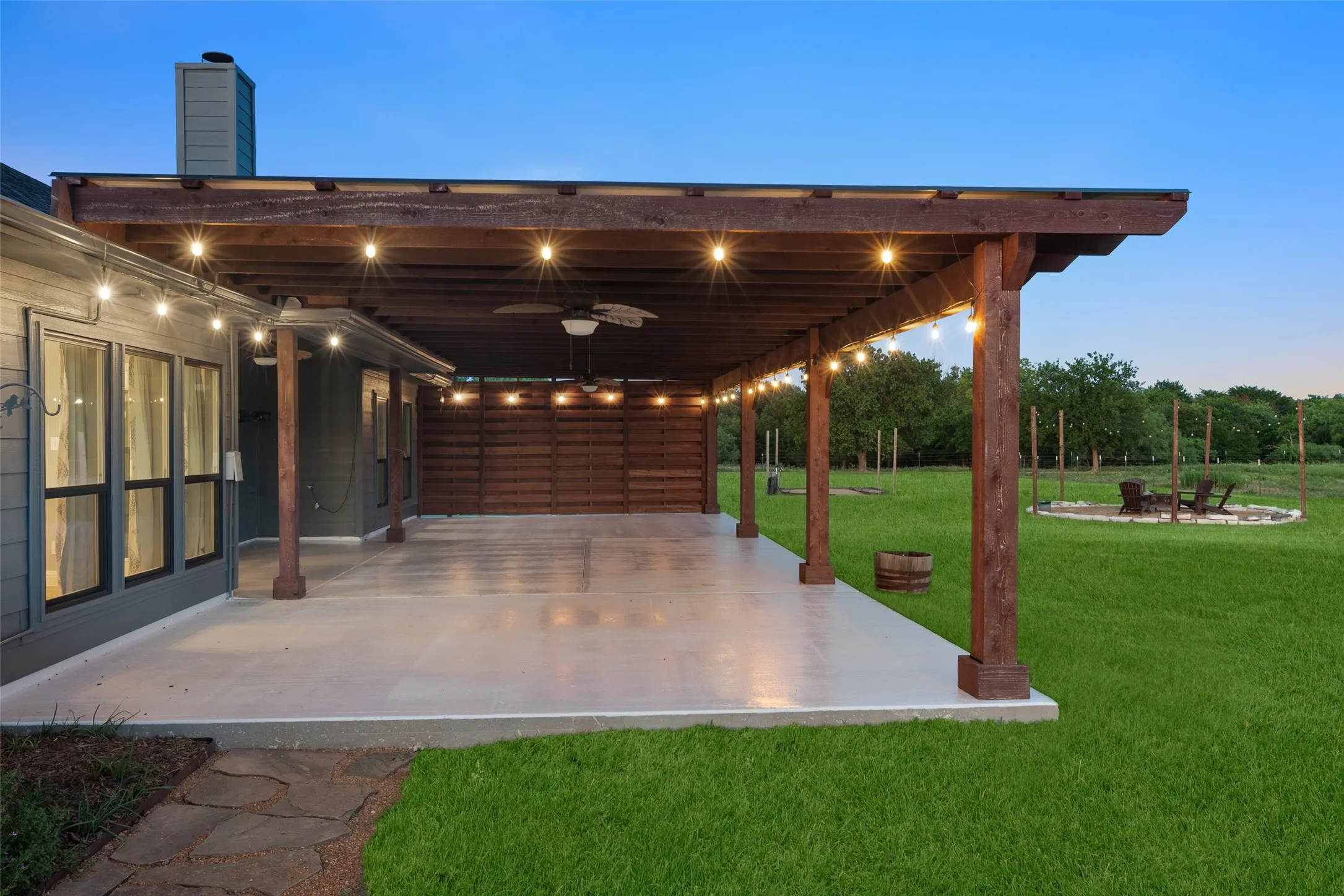 Expansive covered patio with exposed wood beams and string lighting