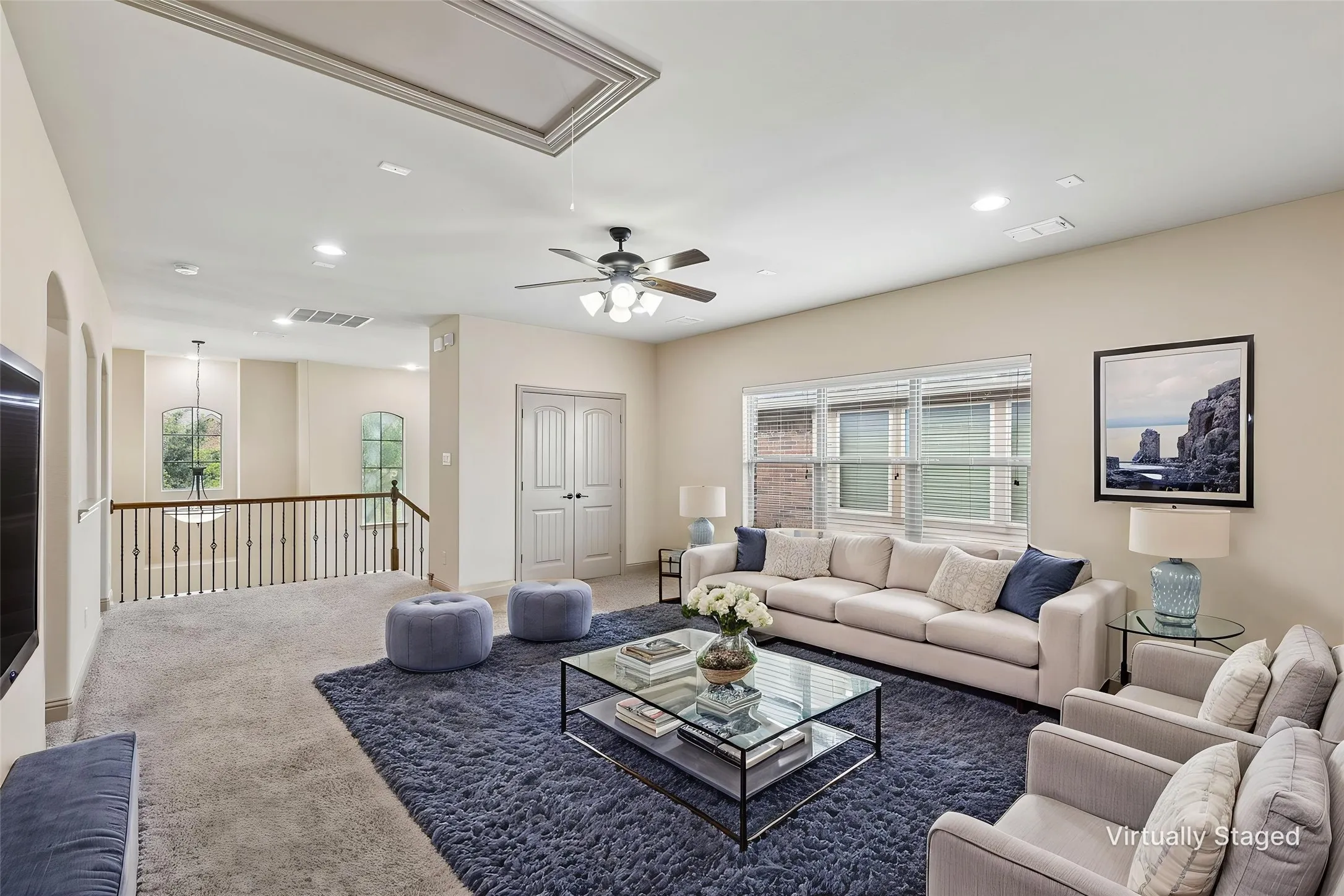Spacious loft area featuring high ceilings with recessed lighting and a ceiling fan
