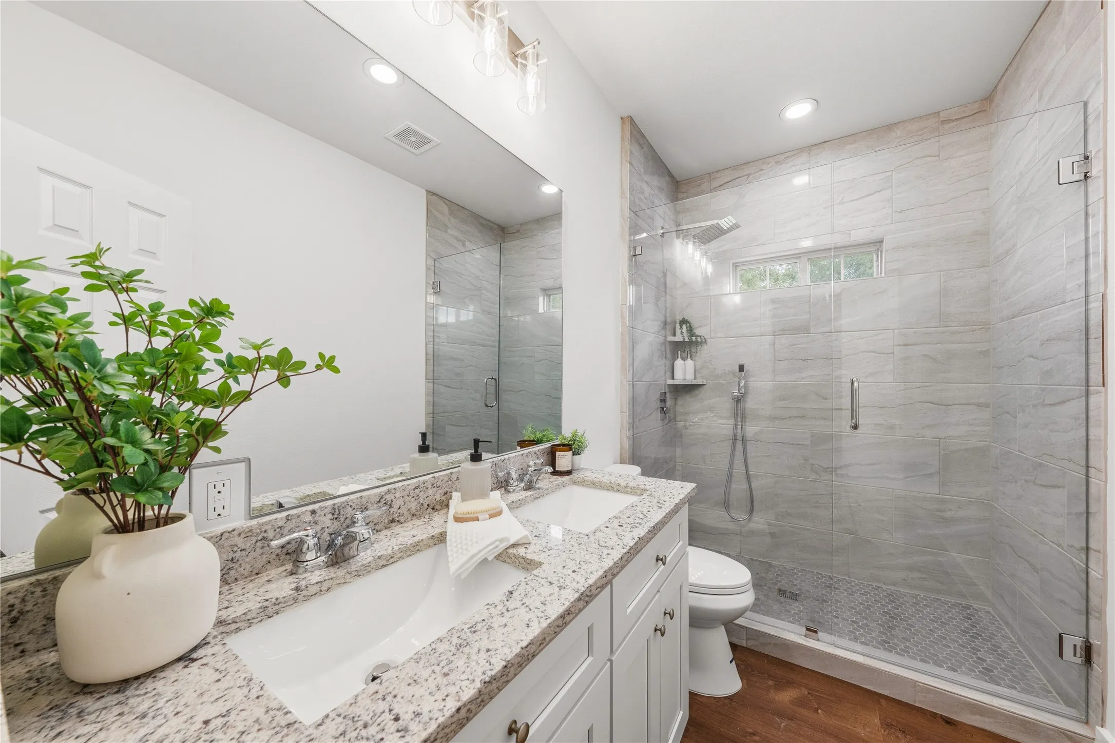 Bathroom featuring a dual vanity with a granite countertop, white cabinetry, and undermount sinks